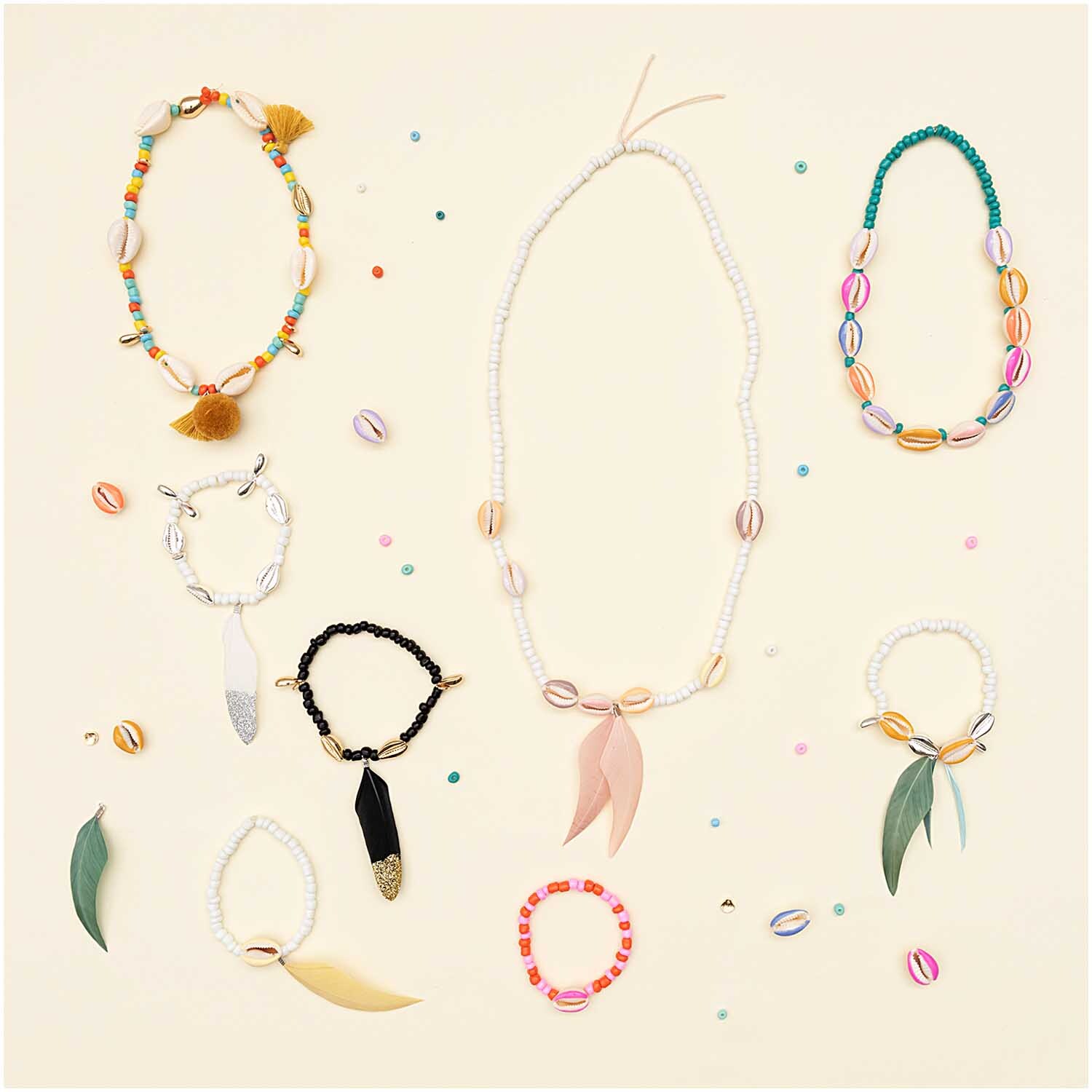 Keramik-Perlen natur multicolor 3mm 30g: Verschiedene Schmuckstücke mit bunten Keramikperlen von Rico Design auf hellem Hintergrund.