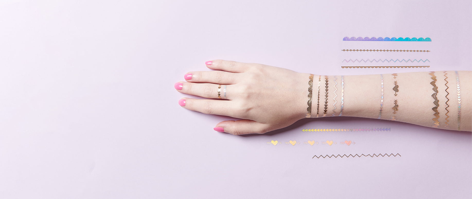 Arm ist mit temporären Tattoos beklebt mit stylishen Motiven im Festival-Look. 