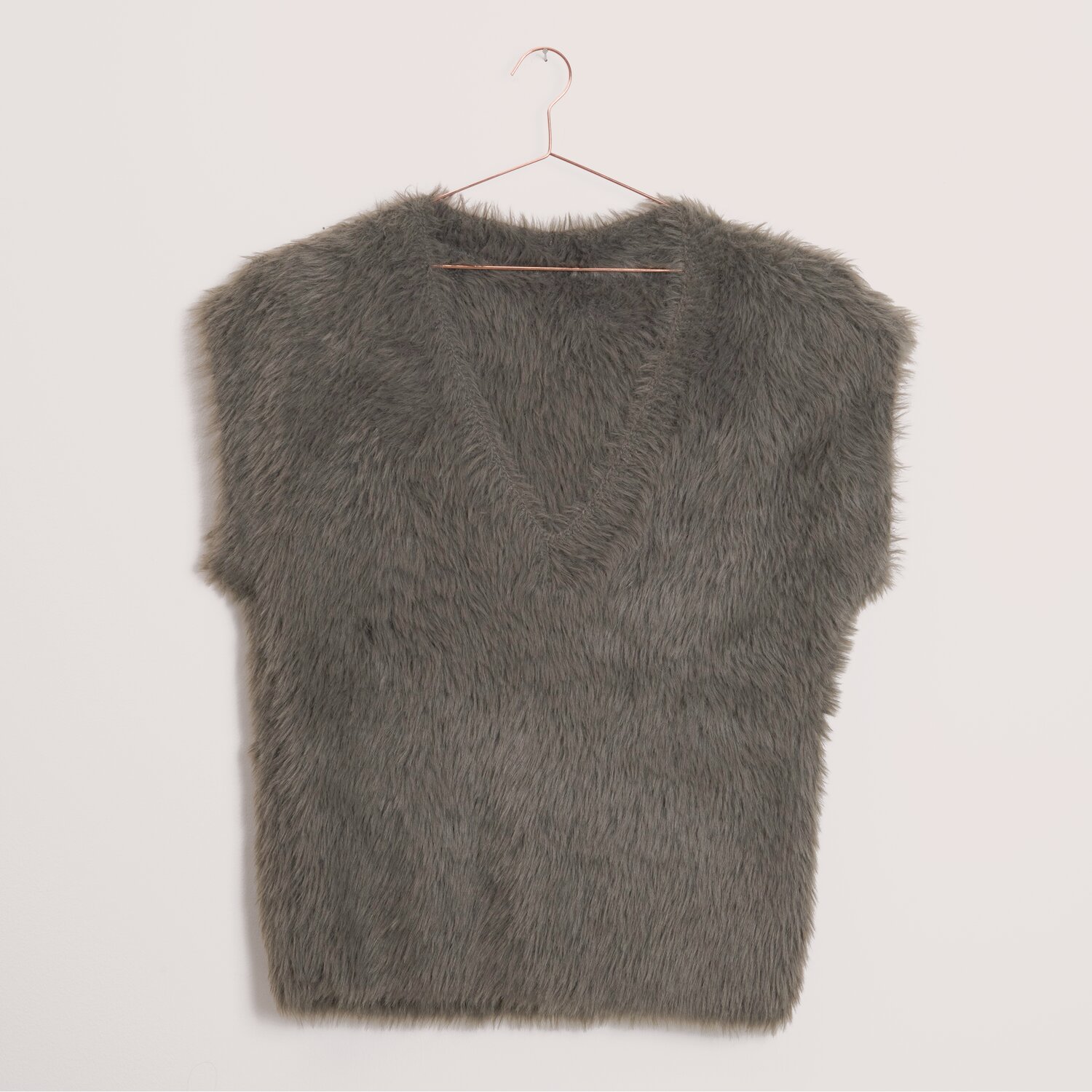 Creative Fur, flauschige Kunstfell-Weste in dunklem Khaki mit V-Ausschnitt von Rico Design, Garnstärke 100g 130m, hängend an schlichtem Metallkleiderbügel