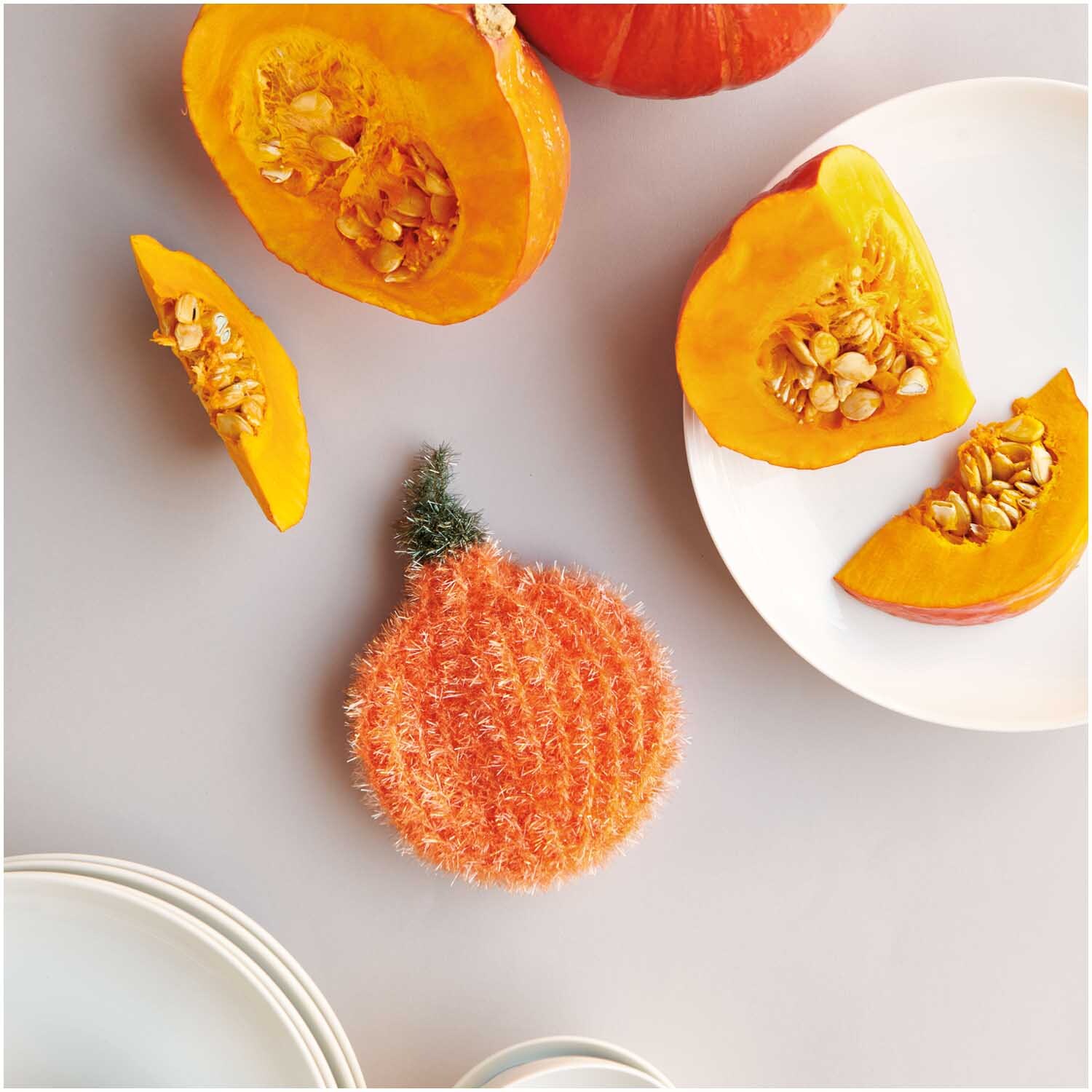 Creative Bubble: Weiches, oranges Garn von Rico Design, ideal für kreative Projekte. Abgebildet mit Kürbisscheiben auf einem Teller.