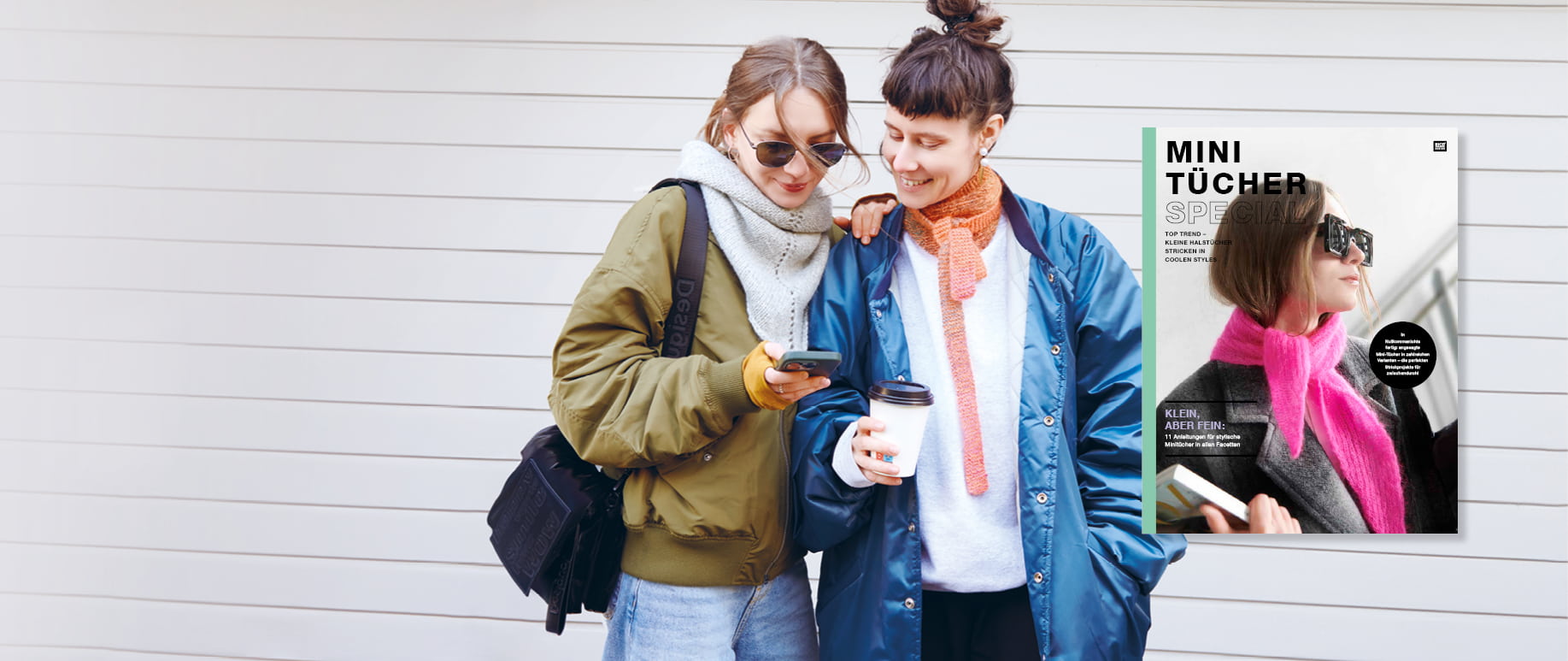 Zwei Frauen stehen beieinander und tragen gestrickte Halstücher.