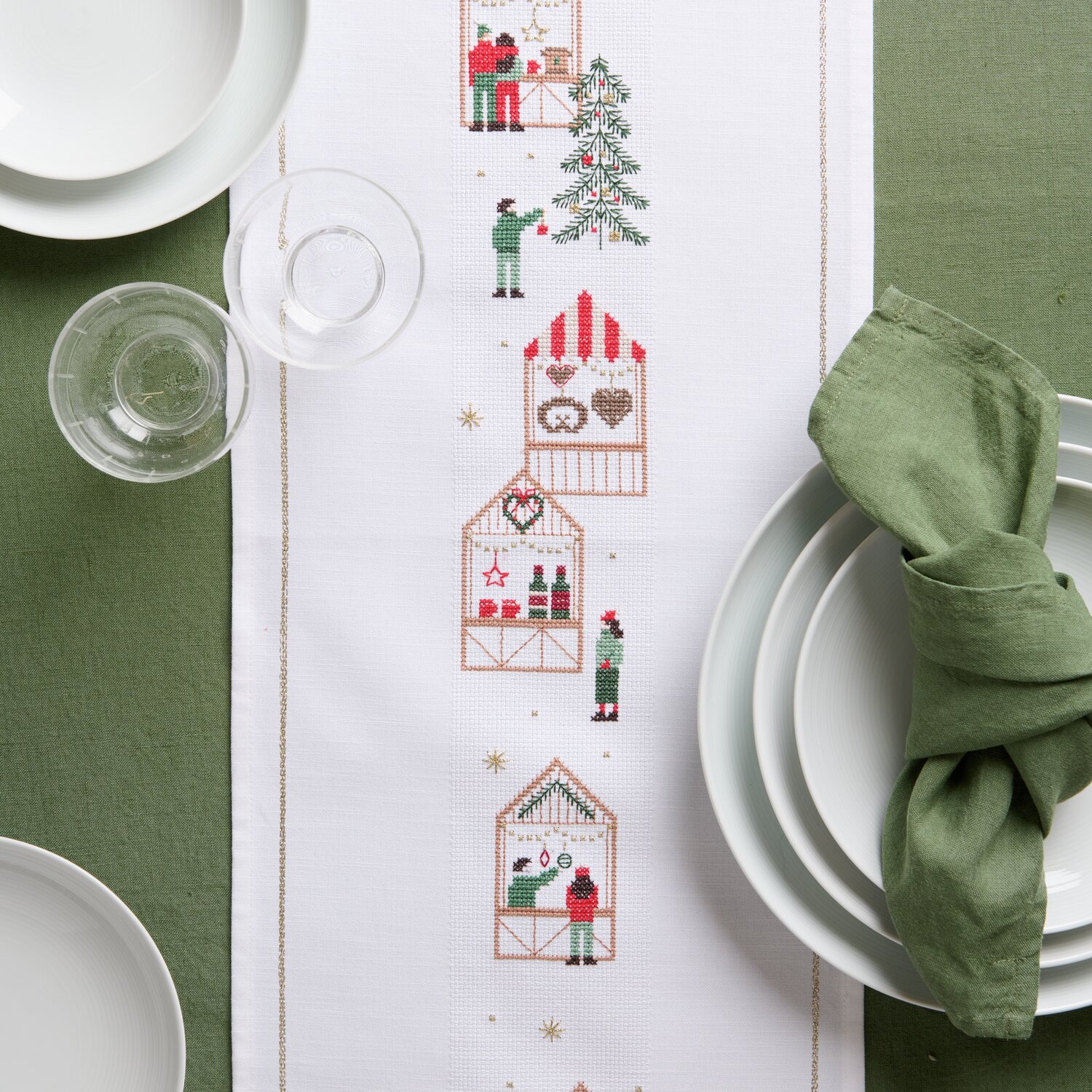 Stickpackung Tischband Weihnachtsmarkt zeigt weihnachtliche Marktszenen auf weißem Stoff, ideal für festliche Tischdekorationen.