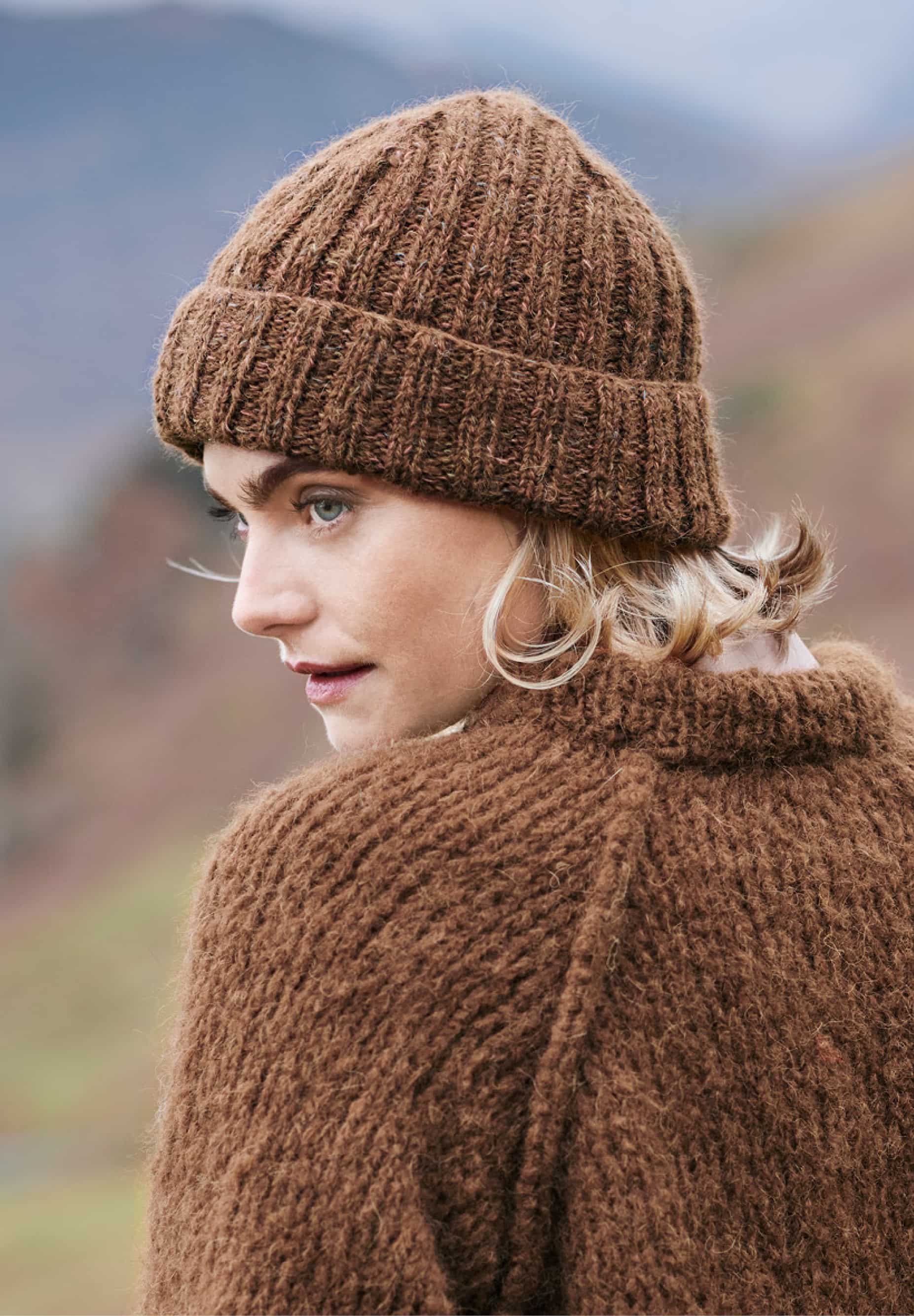 Frau trägt gestrickte Mütze in Braun: Modell 16 aus Lovewool No. 23