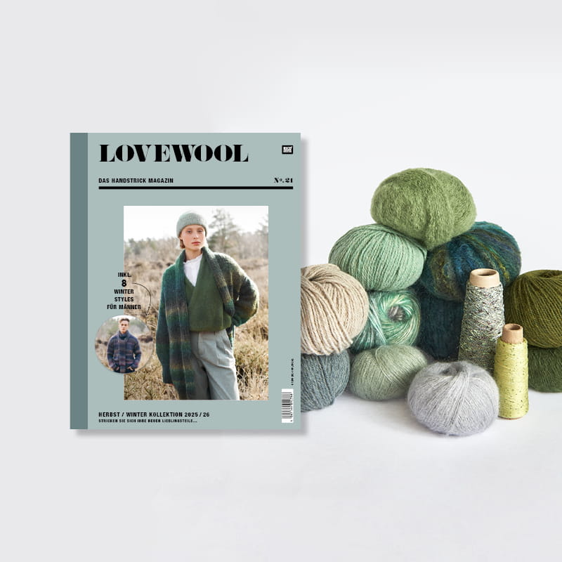 Strickheft Lovewool Nr. 21 neben einem Stapel Wollknäuel