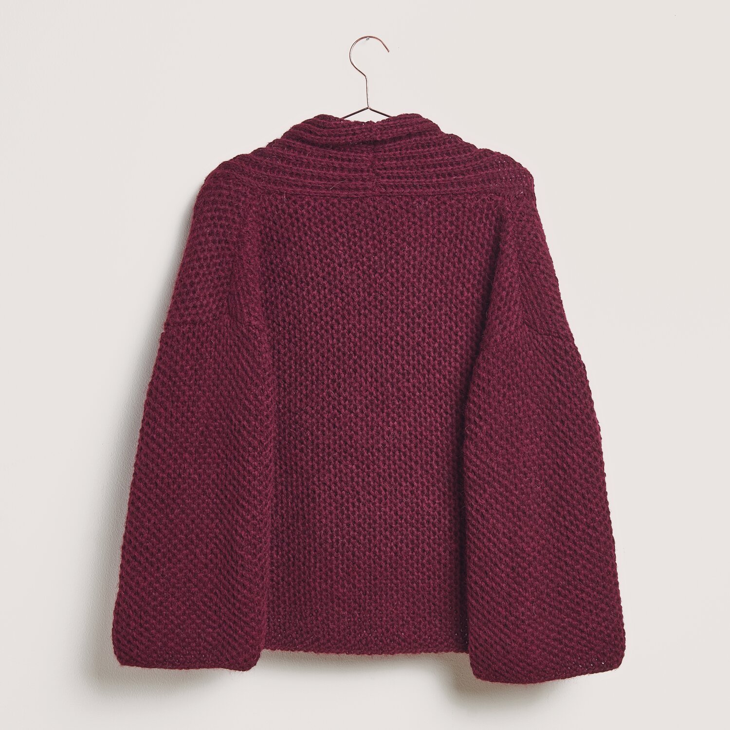 Made by Me No. 21 Herbst-Winter Sprachauswahl deutsch von Rico Design Made by Me No. 21 Herbst-Winter Strickjacke in Bordeaux aus Alpaka-Merino-Mischung, präsentiert auf einem Kleiderbügel.