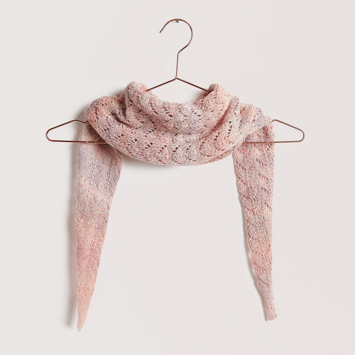 Die Neue Masche No. 12 Frühjahr-Sommer: Rosa Schal aus Fashion Cotton Merino Lace, elegant drapiert auf einem Kleiderbügel.