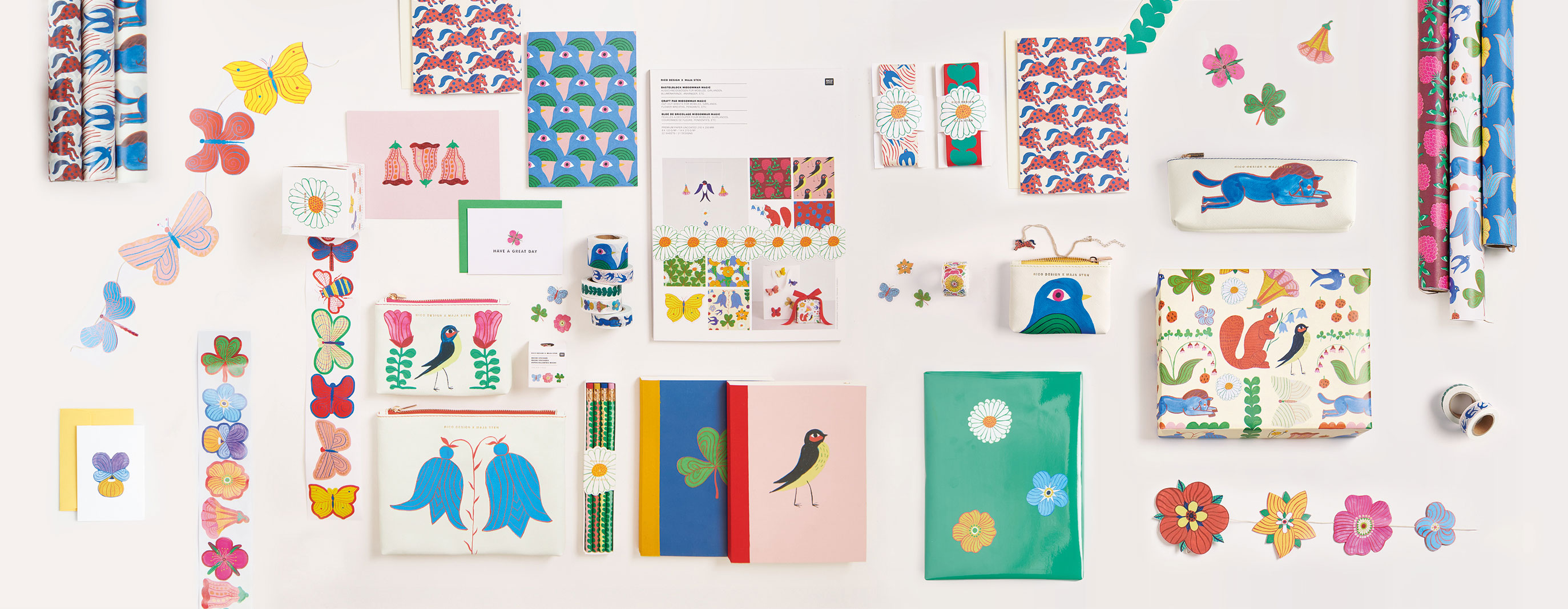 Geschenkpapiere, Sticker, Girlanden, Etuis, Bänder, Notizbücher und Stifte mit Illustrationen von Blumen, Schmetterlingen und Vögeln auf hellem Untergrund arrangiert