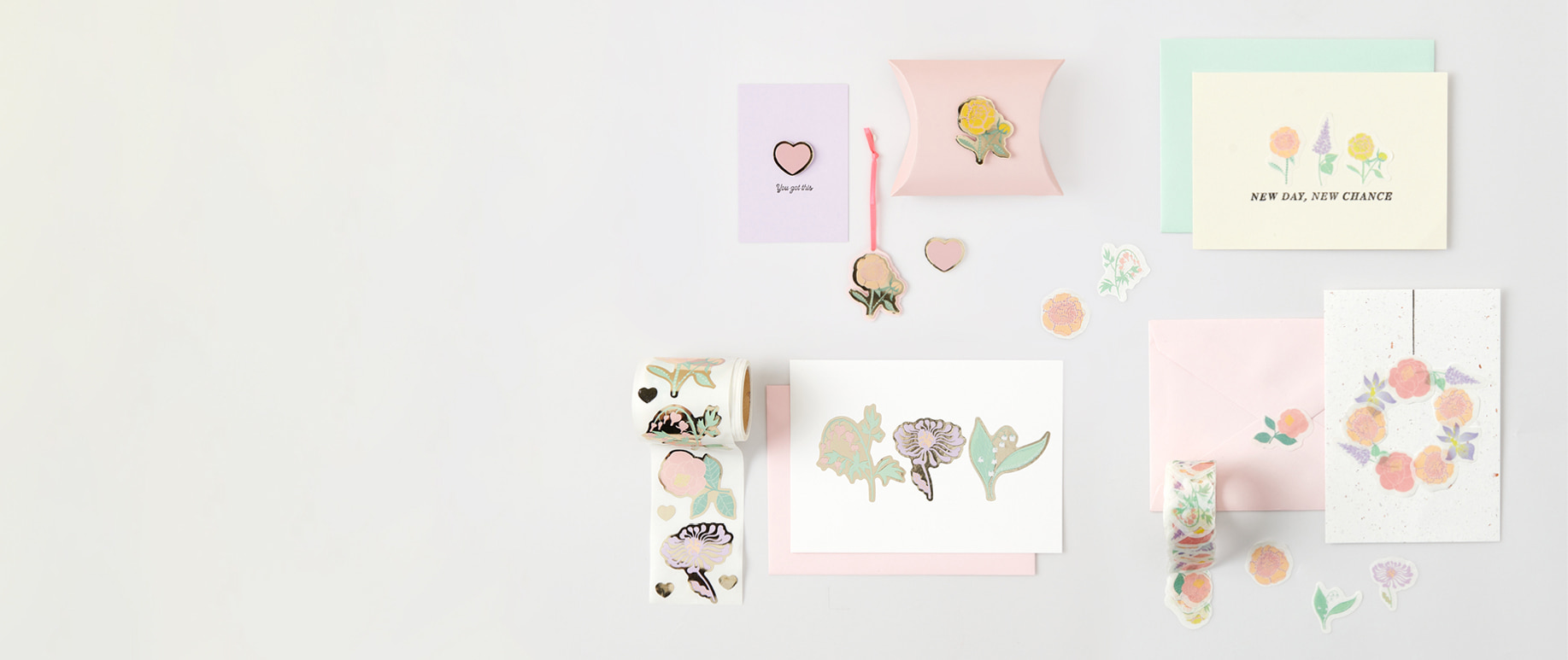 Sticker auf der Rolle und Washisticker mit Blumenmotiven kleben auf Karten und Umschlägen und liegen dekorativ um die Papeterie herum. 