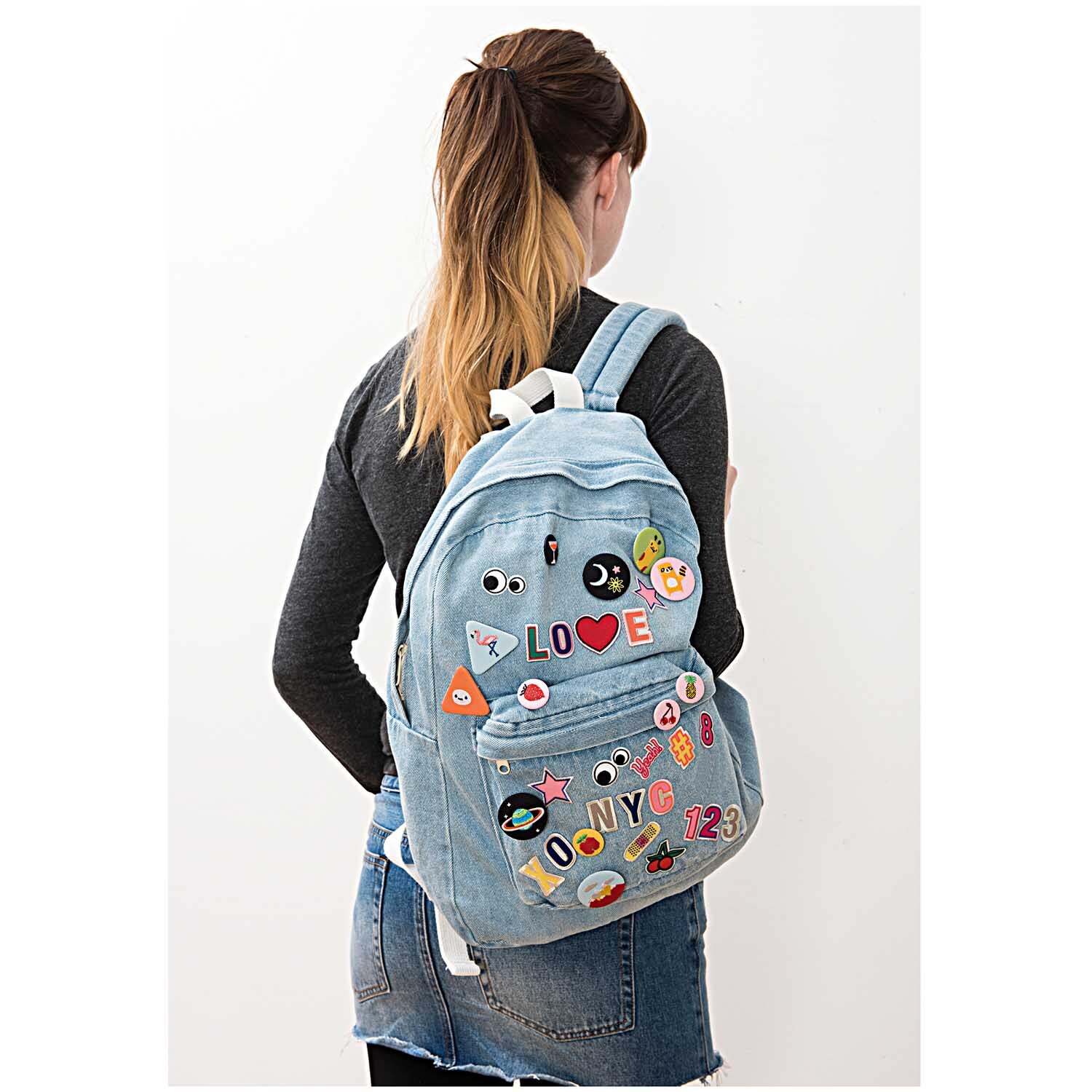 Patch Buchstabe zum Aufbügeln 3,2cm auf einem blauen Rucksack, verziert mit bunten Motiven und Emojis. Ideal für kreative Designs.