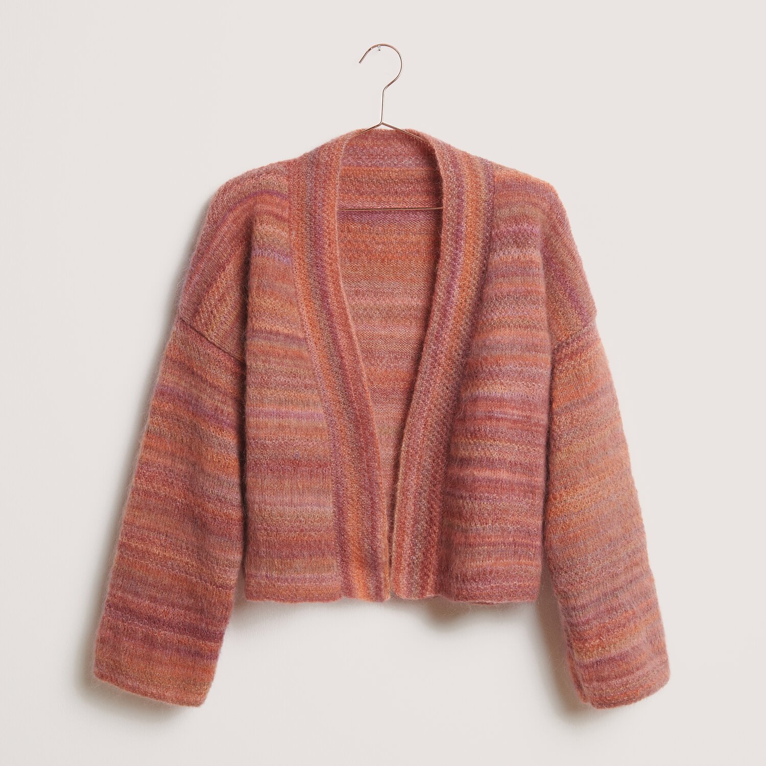 Strickset Kimono-Jacke Modell 01 in warmen Rottönen, präsentiert auf einem Kleiderbügel. Ideal für den Winter.