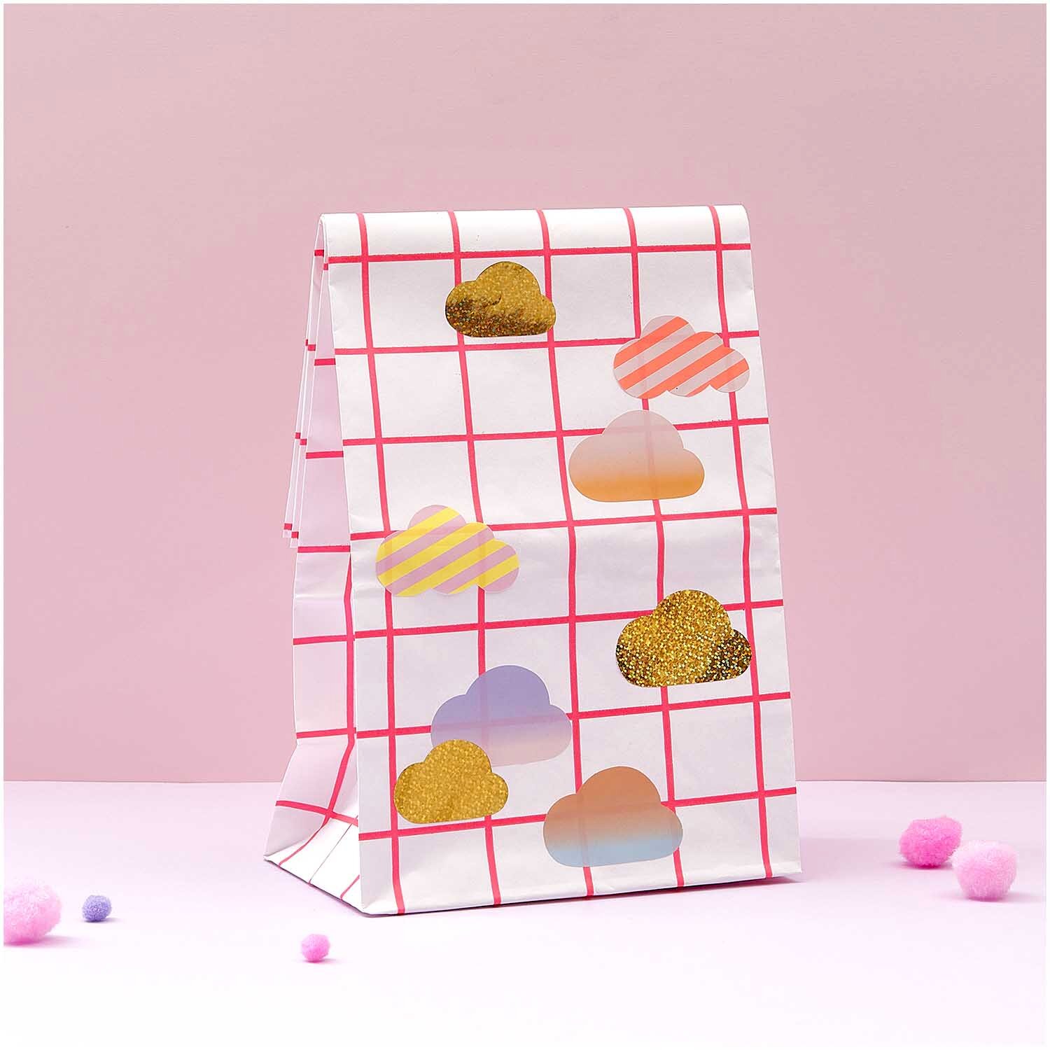 Paper Poetry Sticker Wolken auf einer weißen Tüte mit rotem Karomuster, dekoriert in Pastellfarben.