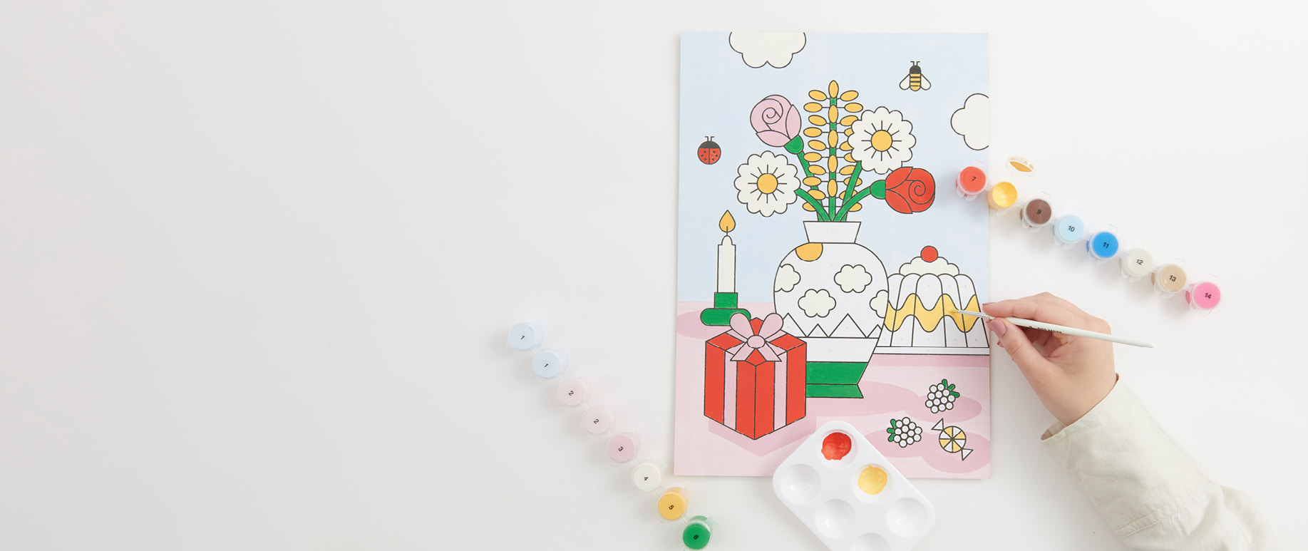 Malen nach Zahlen Set "Eye Candy" wird ausgemalt. Farbtöpfchen umgeben das Bild.