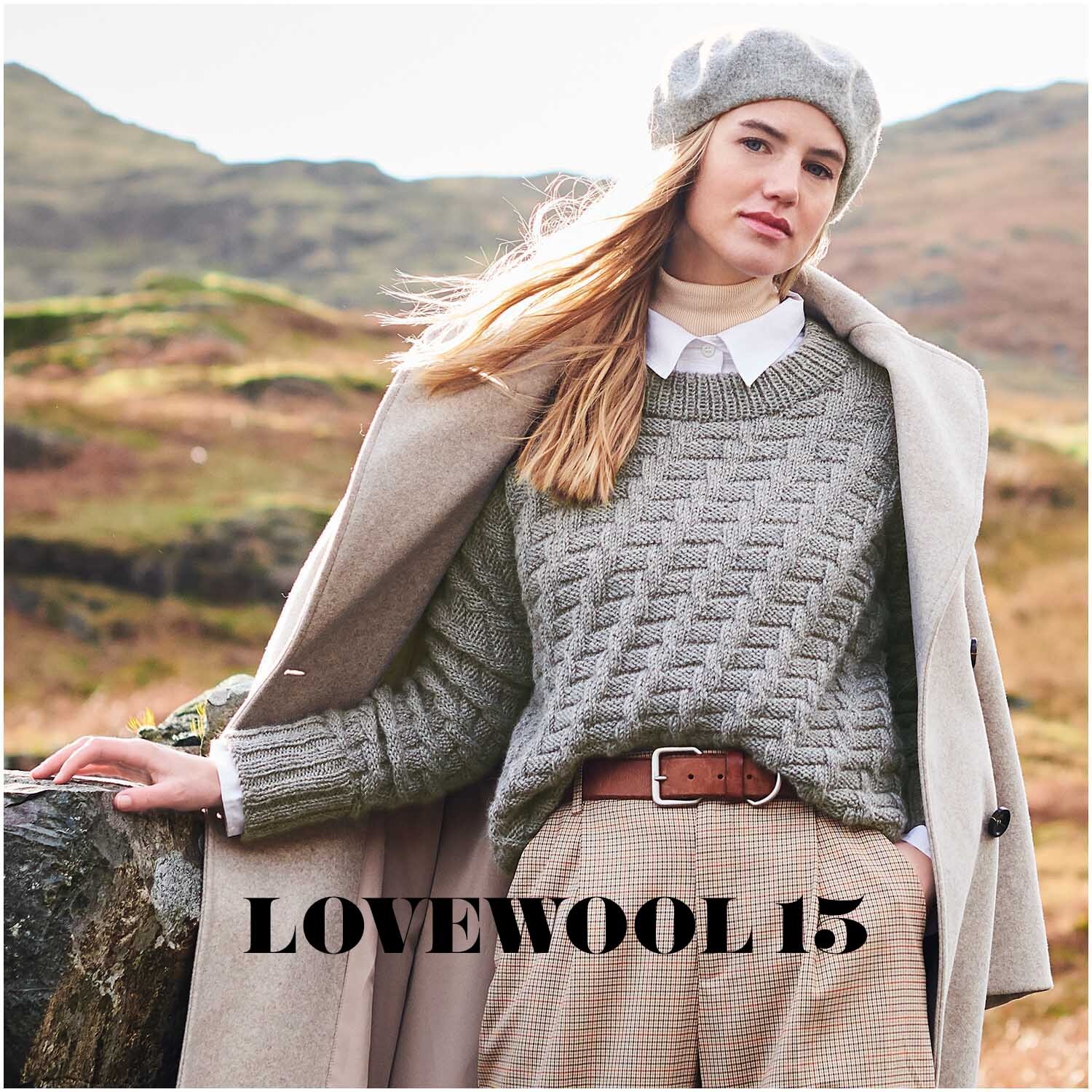 Essentials Baby Alpaca & Merino aran: Frau in grauem Strickpullover und Mantel in Landschaft. Ideal für Herbstmode.