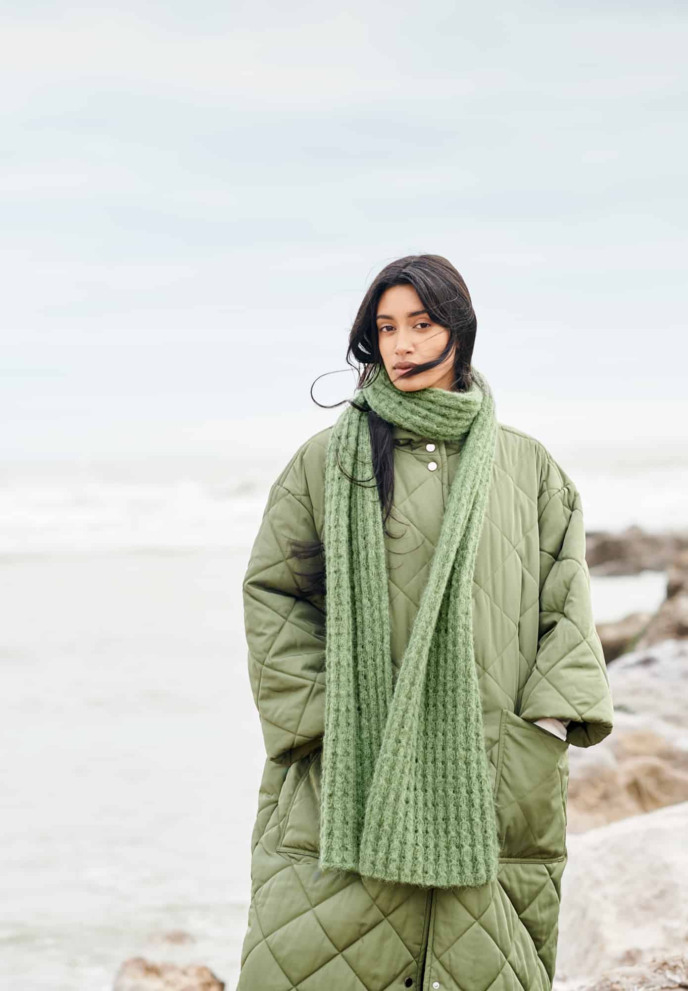 Frau trägt gestrickten Schal in Grün: Modell 07 aus Lovewool No. 21
