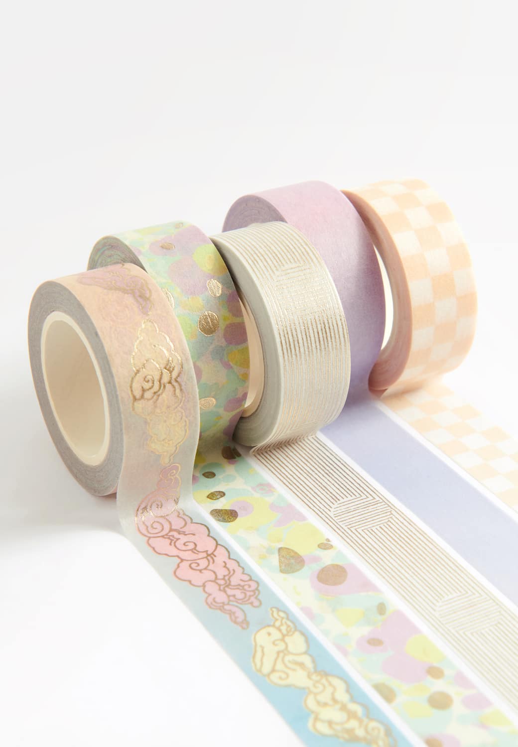 Tape Rollen mit Motiven in Pastelltönen liegen ausgerollt auf hellem Hintergrund.