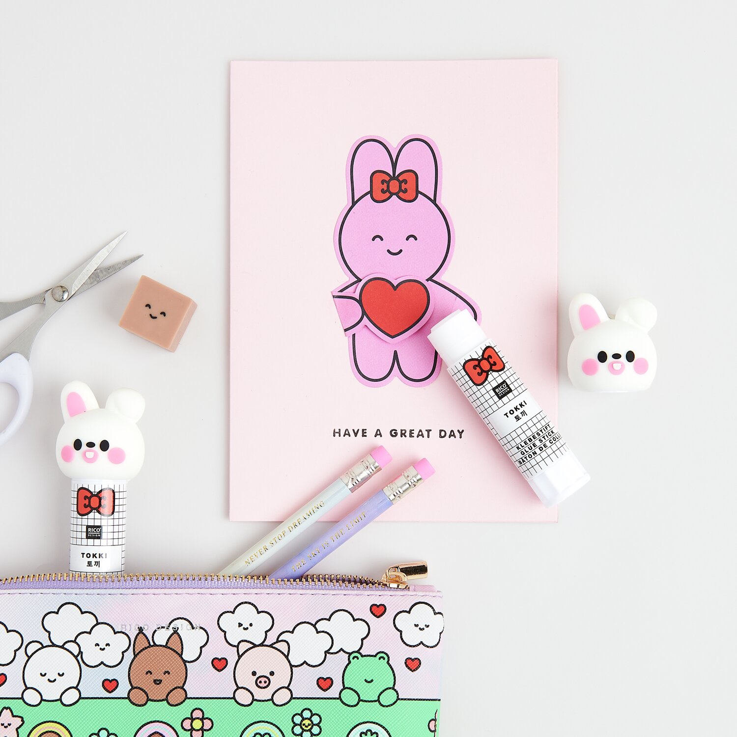 Paper Poetry Klebestift Hase Weiß neben rosa Karte mit Hase, Stiften und bunter Federtasche.