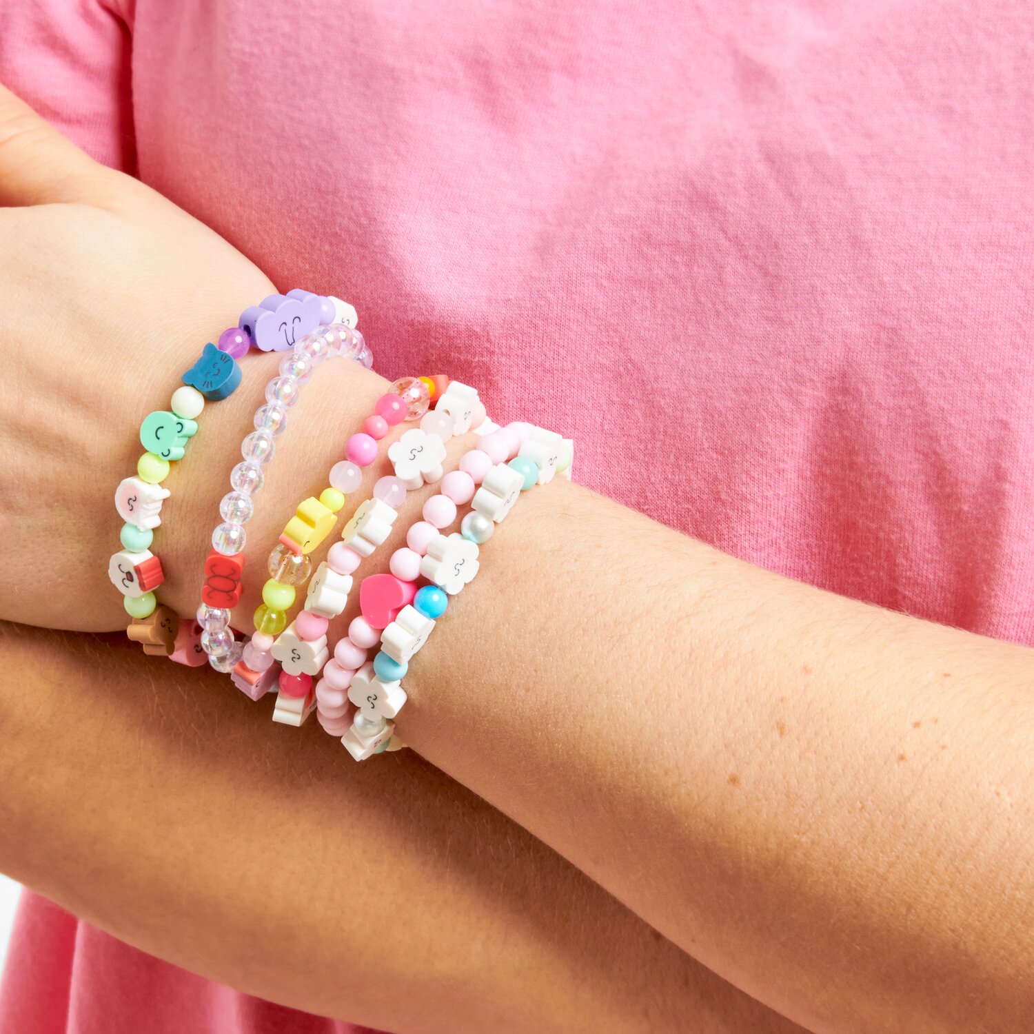 Armband Cloud Sunrise: Bunte Perlenarmbänder am Handgelenk, getragen zu einem rosa T-Shirt.