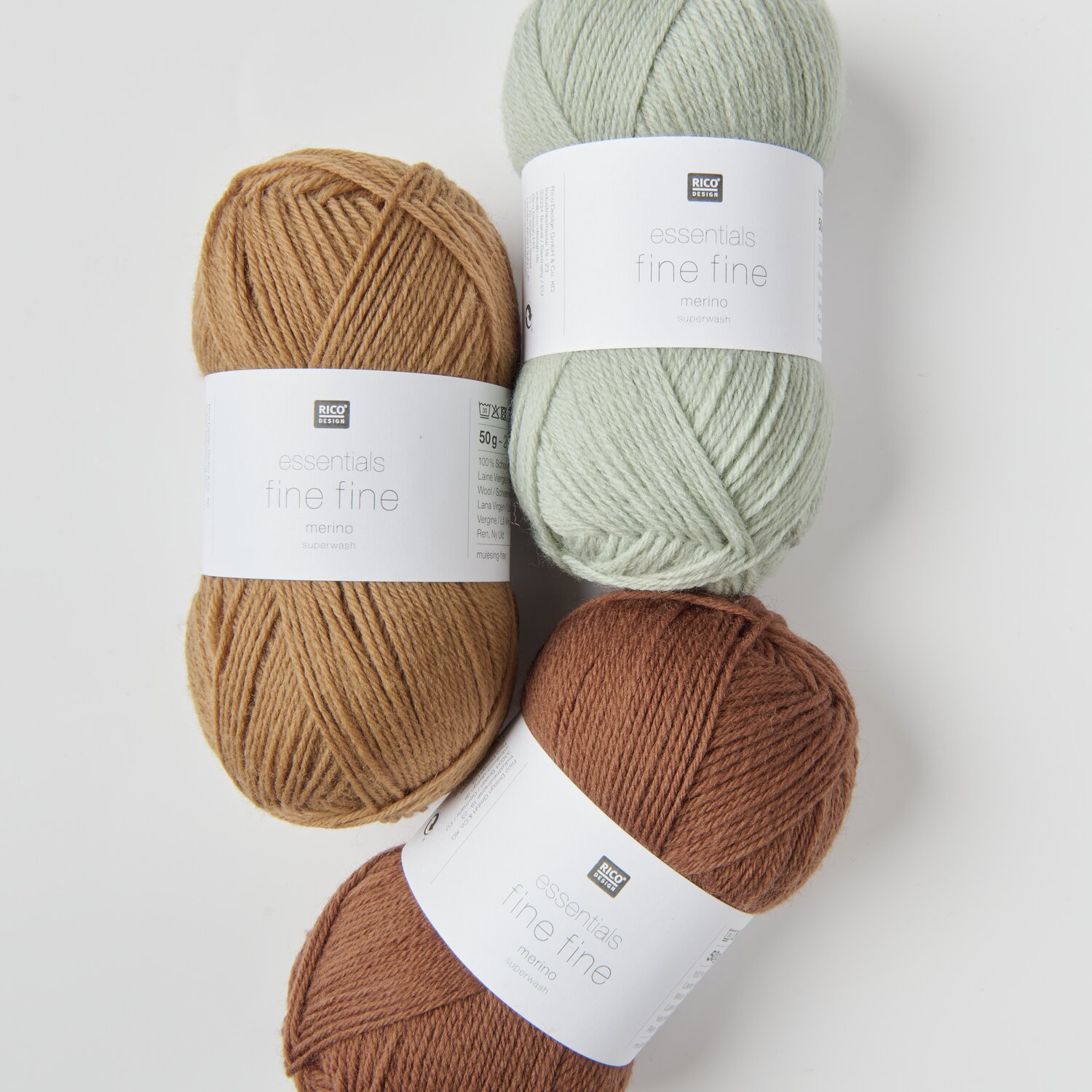 Essentials Fine Fine Merino: Drei Wollknäuel in Beige, Hellgrün und Braun von Rico Design, 50g 200m. Ideal für Strickprojekte.