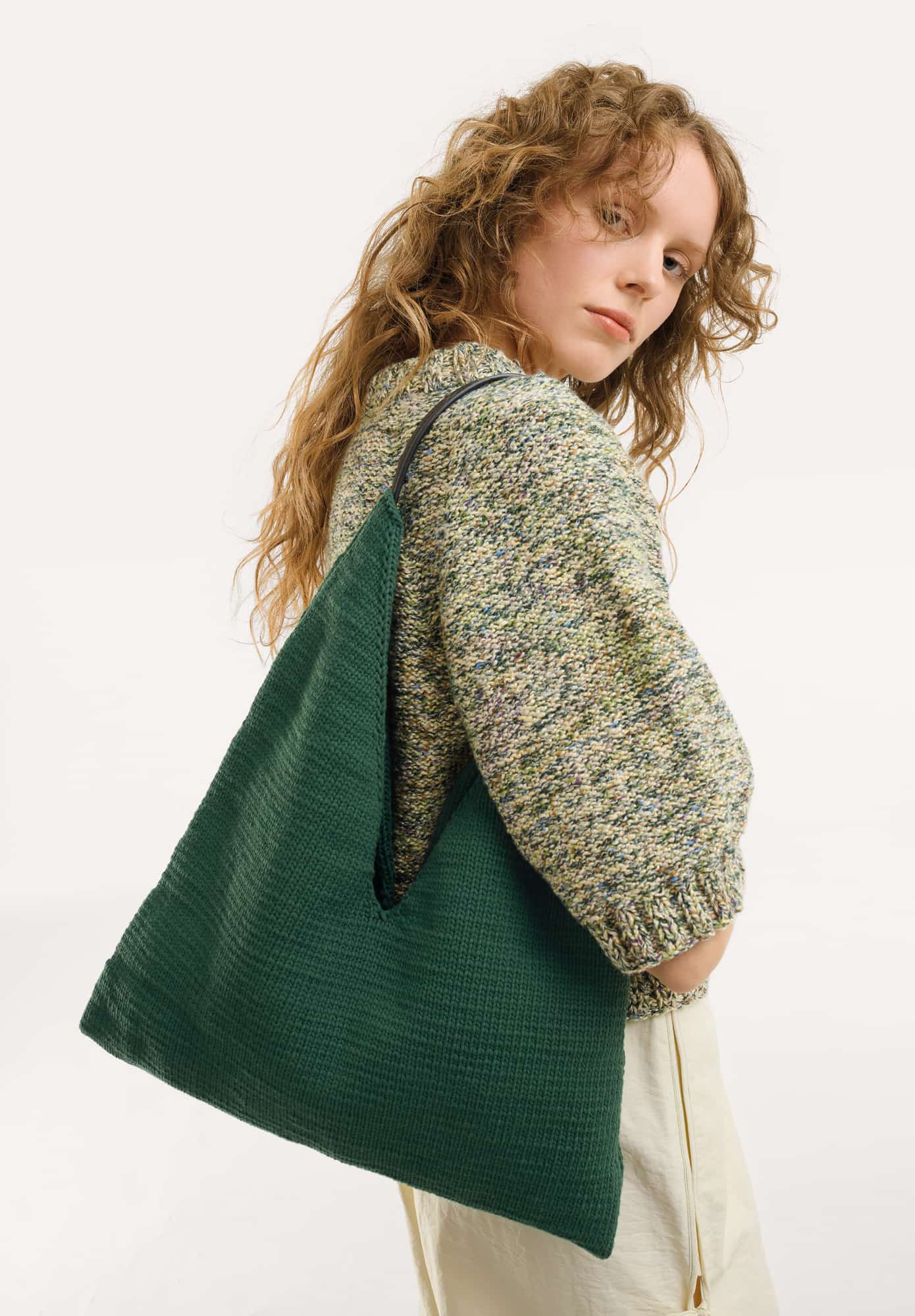 Frau trägt gestrickte Tasche in Dunkelgrün: Modell 22 aus Made by Me No. 22