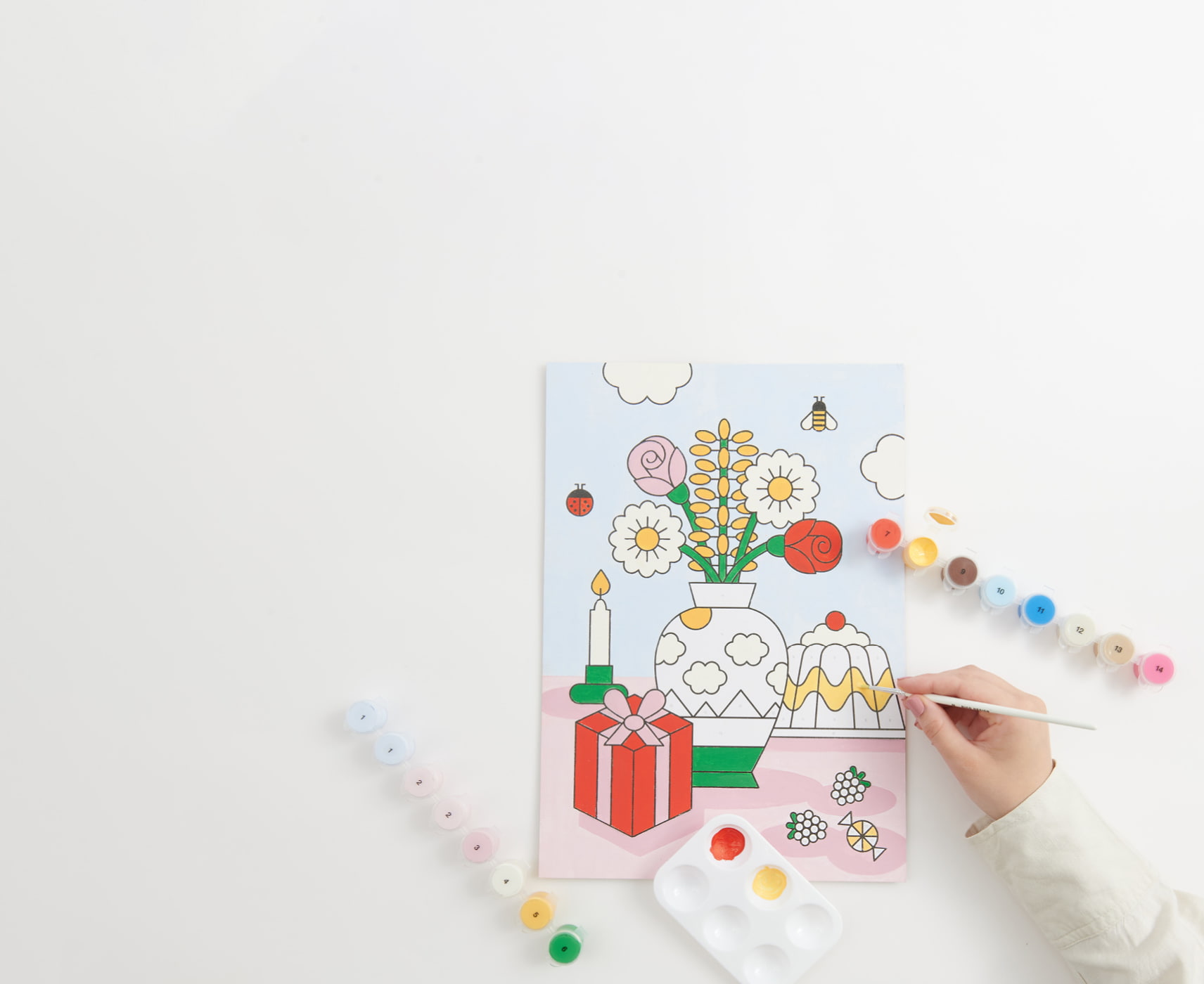 Malen nach Zahlen Set "Eye Candy" wird ausgemalt. Farbtöpfchen umgeben das Bild.