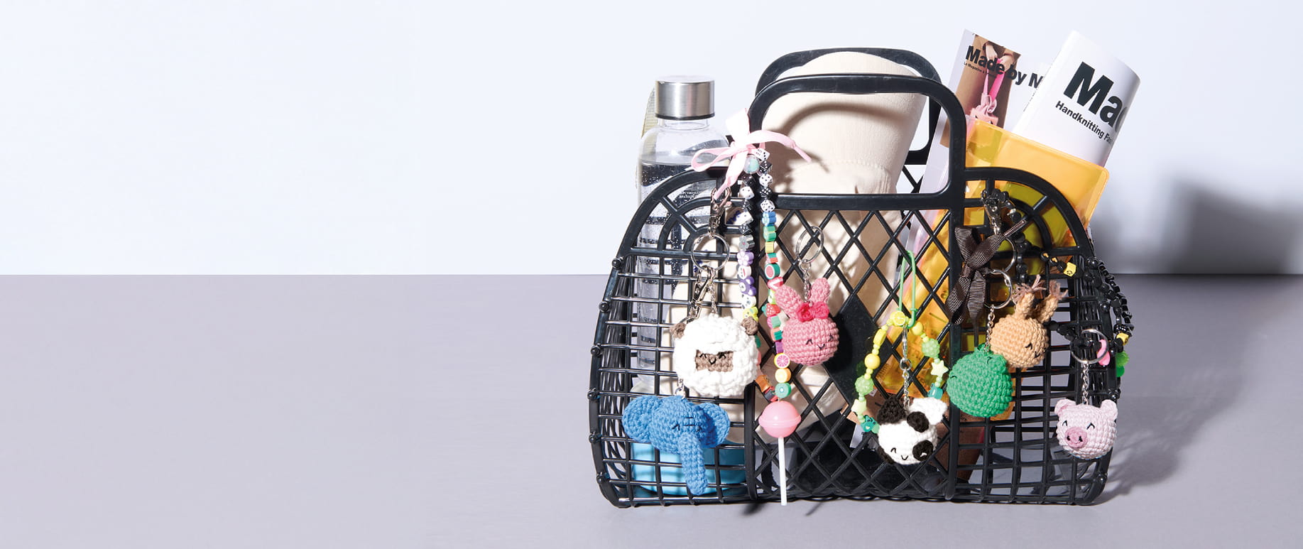Ein gefüllter Korb ist mit vielen gehäkelten Tier-Anhängern geschmückt.