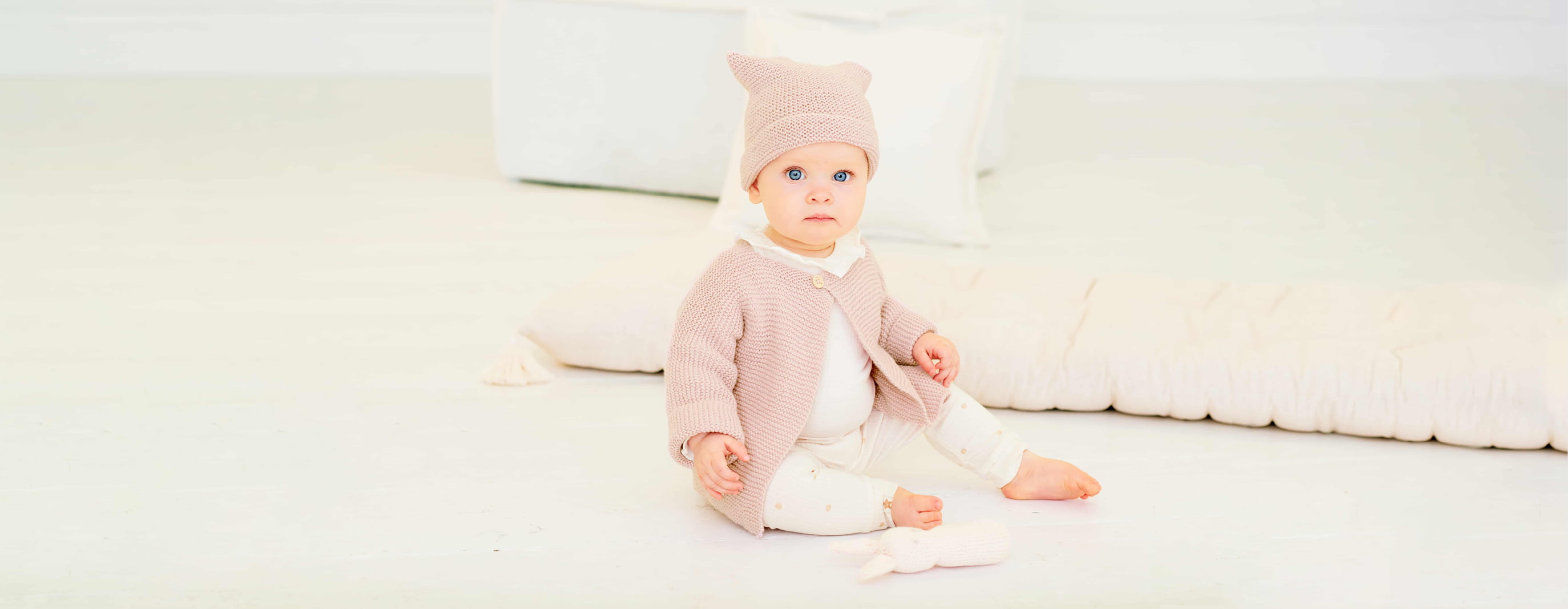 Kleinkind mit gestrickter Jacke und Mütze