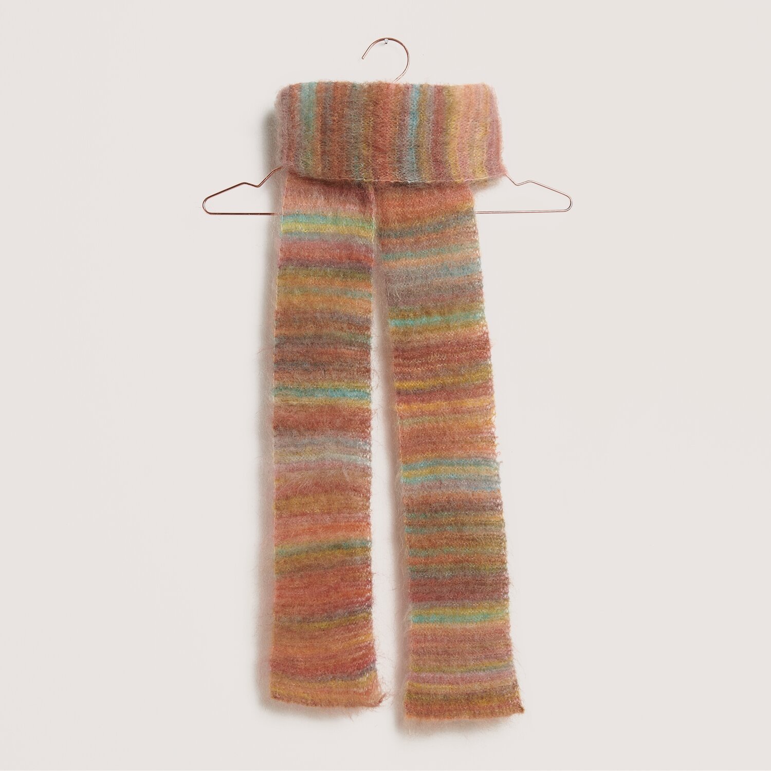 Made by Me No. 21 Herbst-Winter Sprachauswahl deutsch von Rico Design Stickset Schal Modell 30 aus Made by Me No. 21, gestrickt in bunten Streifen auf einem Kleiderbügel.