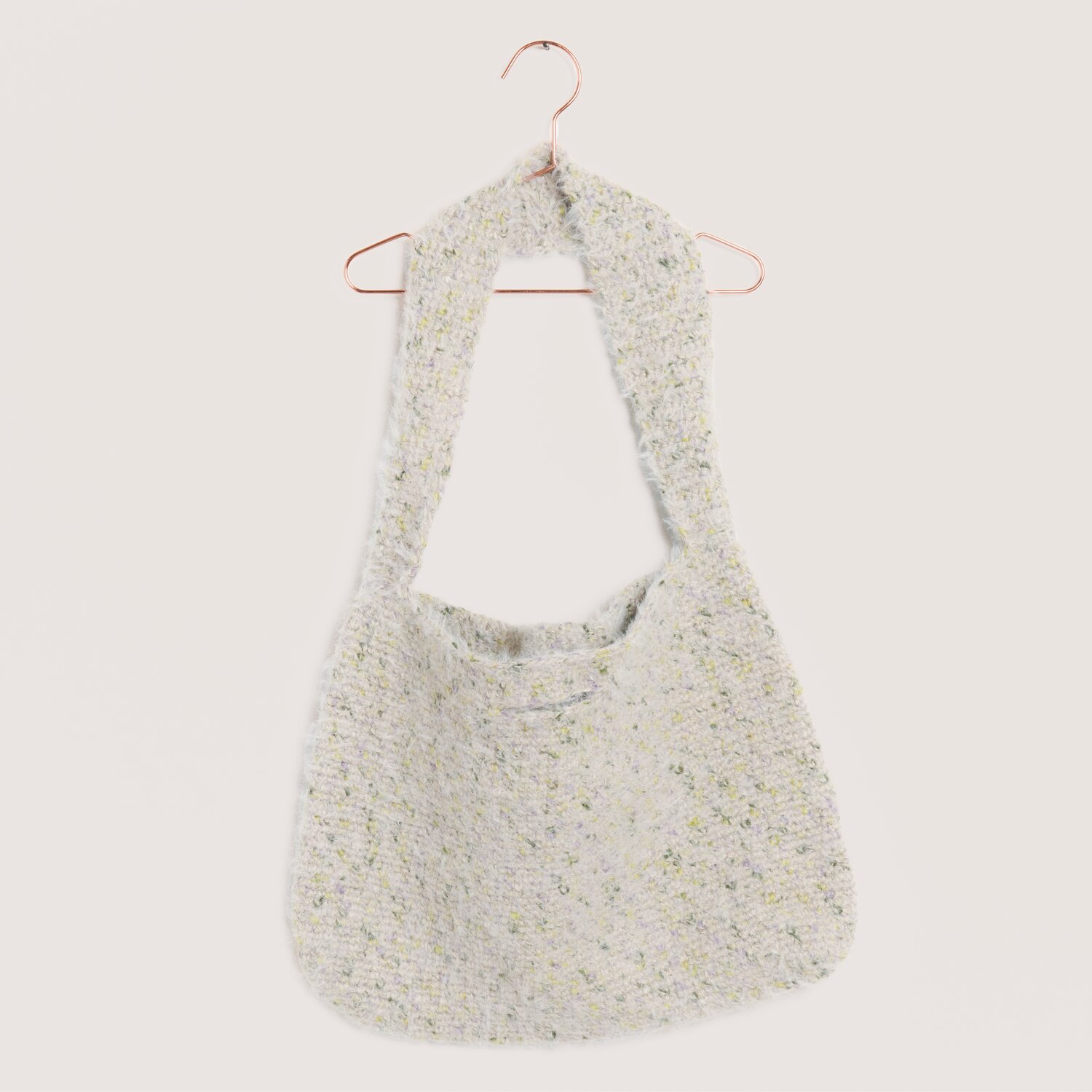 Made by Me No. 22 Frühjahr-Sommer: Handgestrickte Tasche in Oliv- und Taupetönen, hängend an einem Kupferbügel.