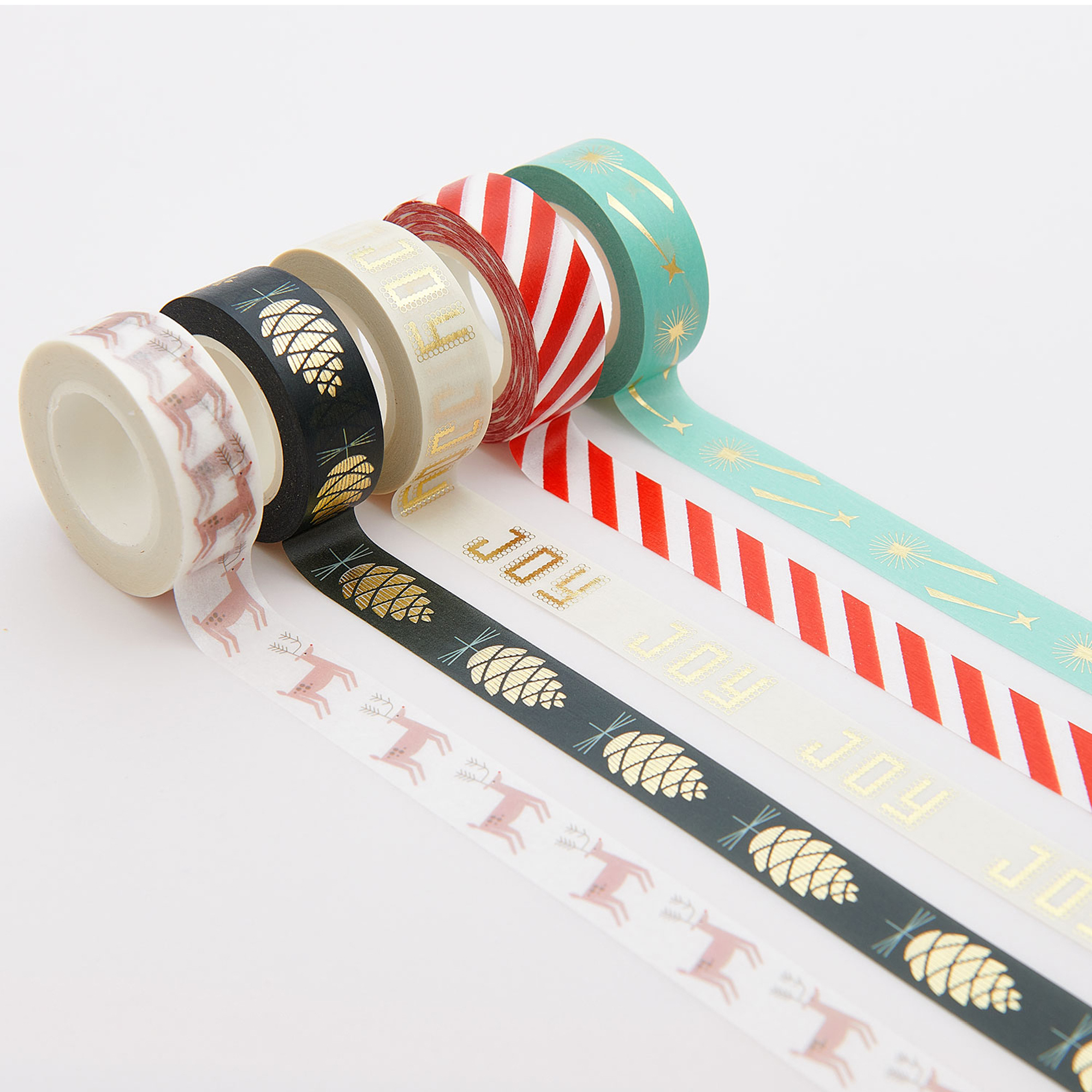 Washi Tape Rollen mit weihnachtlichen Mustern ausgerollt auf weißem Hintergrund