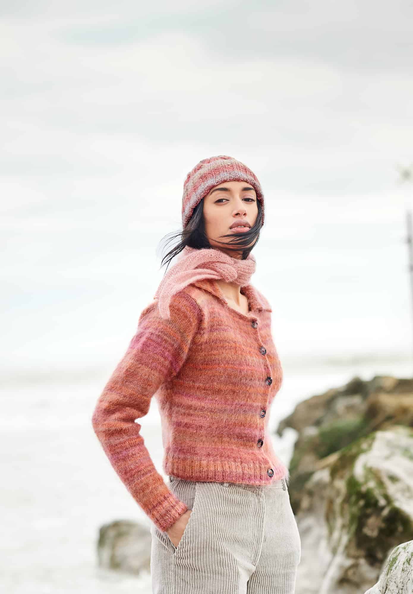Frau trägt gestrickte Mütze in Rot- und Naturtönen: Modell 06 aus Lovewool No. 21