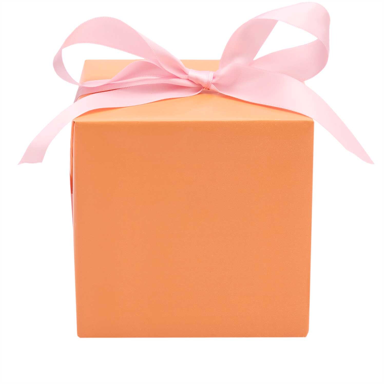Paper Poetry Geschenkpapier umhüllt eine honigfarbene Schachtel mit rosa Schleife, ideal für stilvolle Geschenke.
