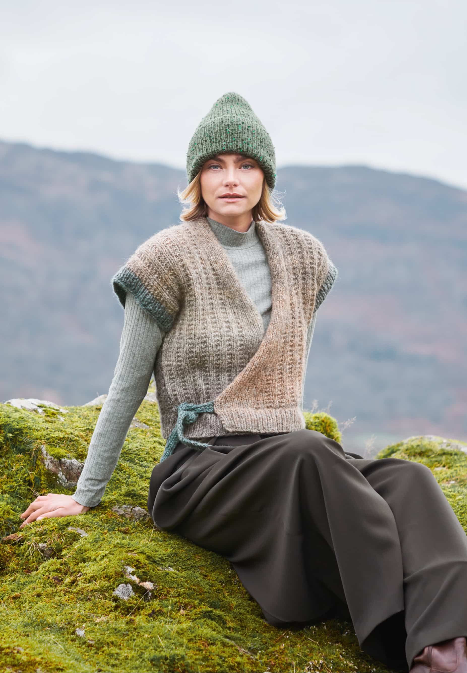 Frau trägt gestrickte Weste mit Farbverlauf in gedeckten Tönen: Modell 15 aus Lovewool No. 23