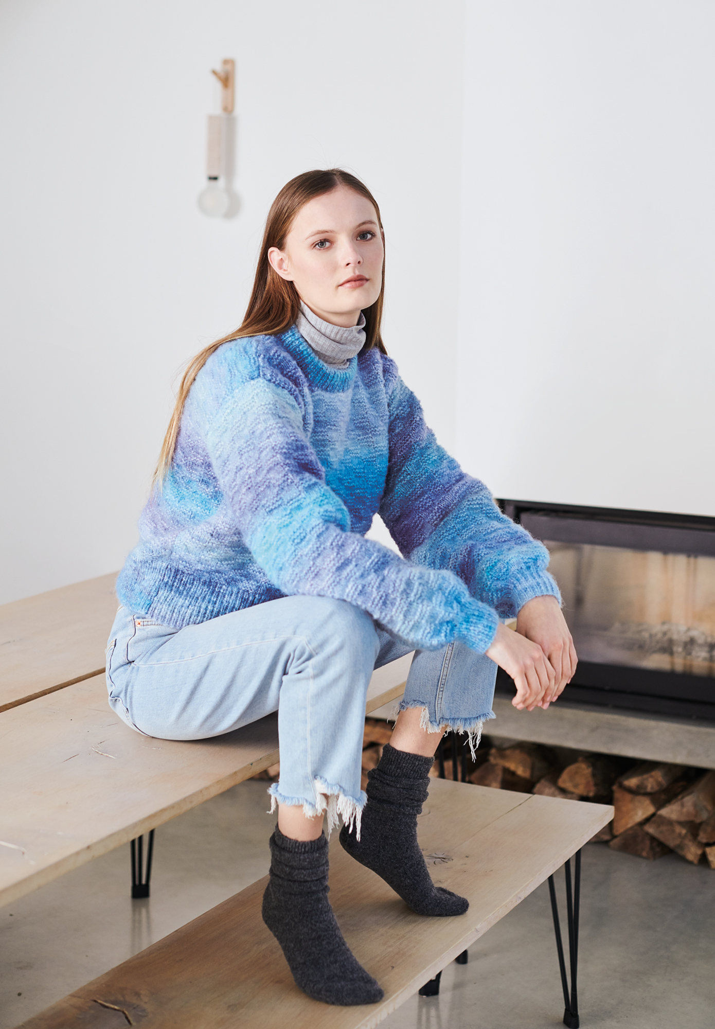 Frau trägt gestrickten Pullover in Blautönen: Modell 30 aus Lovewool No. 19