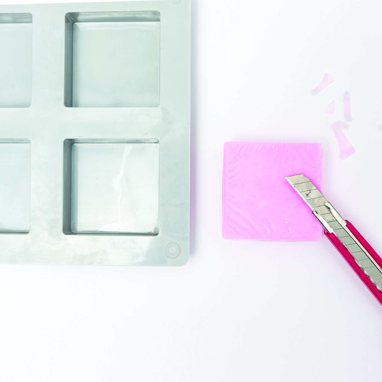 Ein Cutter schneidet Unebenheiten von einem Seifenstück ab
