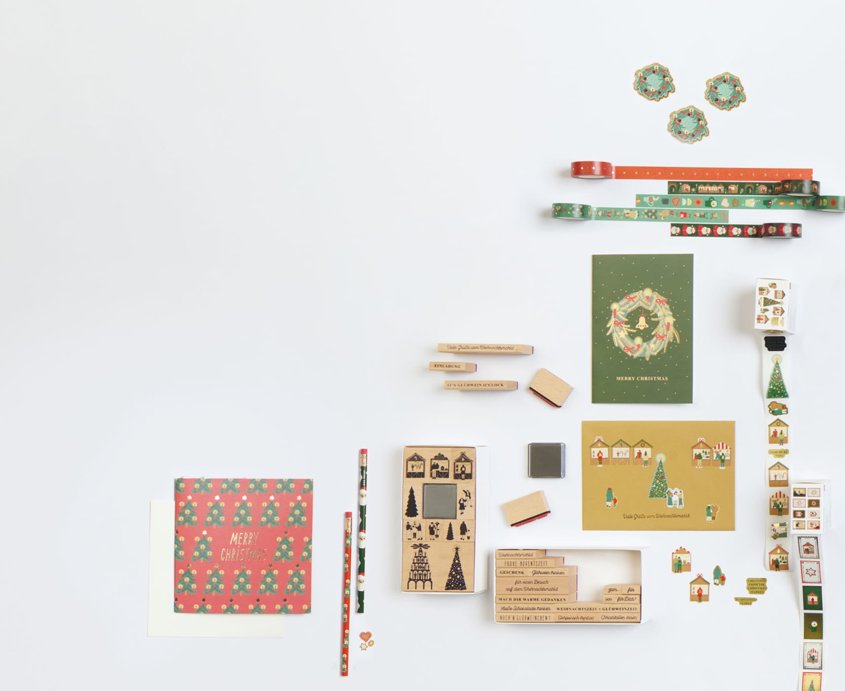 Sticker, Stempel, Karten und Glanzbilder mit Motiven vom Weihnachtsmarkt sind auf grauem Hintergrund angeordnet.