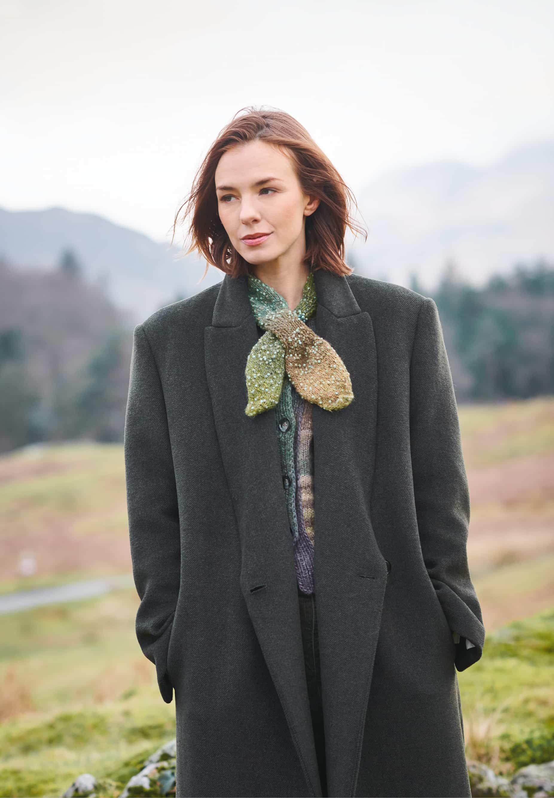 Frau trägt gestricktes Minituch in Grüntönen: Modell 22 aus Lovewool No. 23