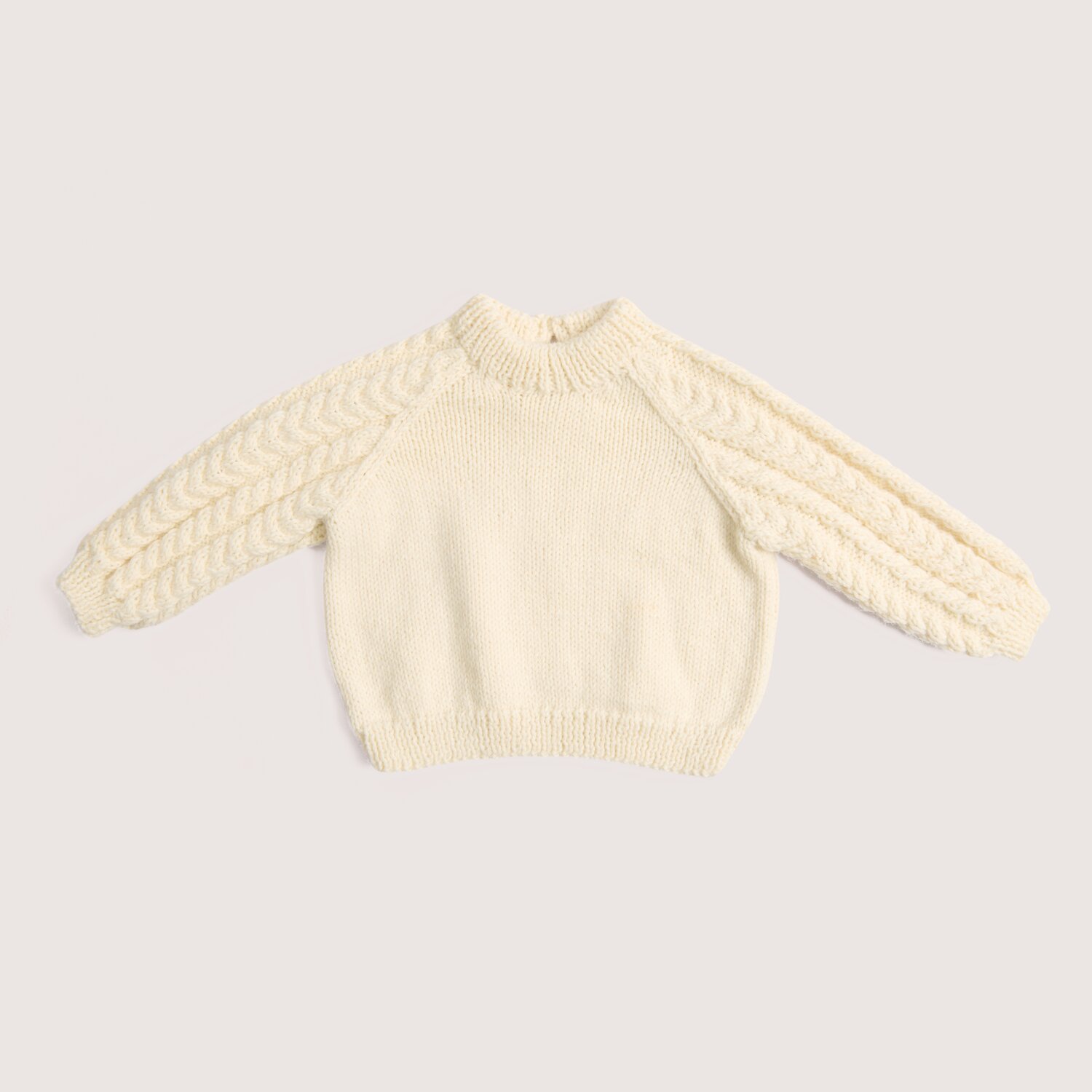 Rico Baby 044, kuscheliger Baby-Pullover in Offwhite mit Raglanärmeln, Zopfmuster an den Ärmeln, gestrickt aus Rico Design Baby Dream dk uni, 50g 115m
