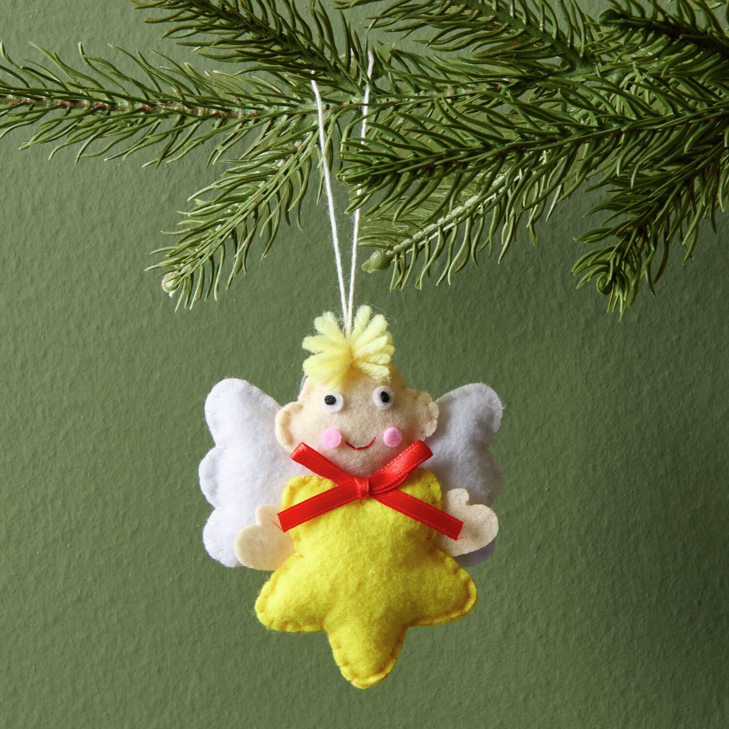 Aufhänger Filz-Engel mit Stern Gelb: Niedlicher Engel aus Filz mit gelbem Stern und roter Schleife, ideal als Weihnachtsdekoration.