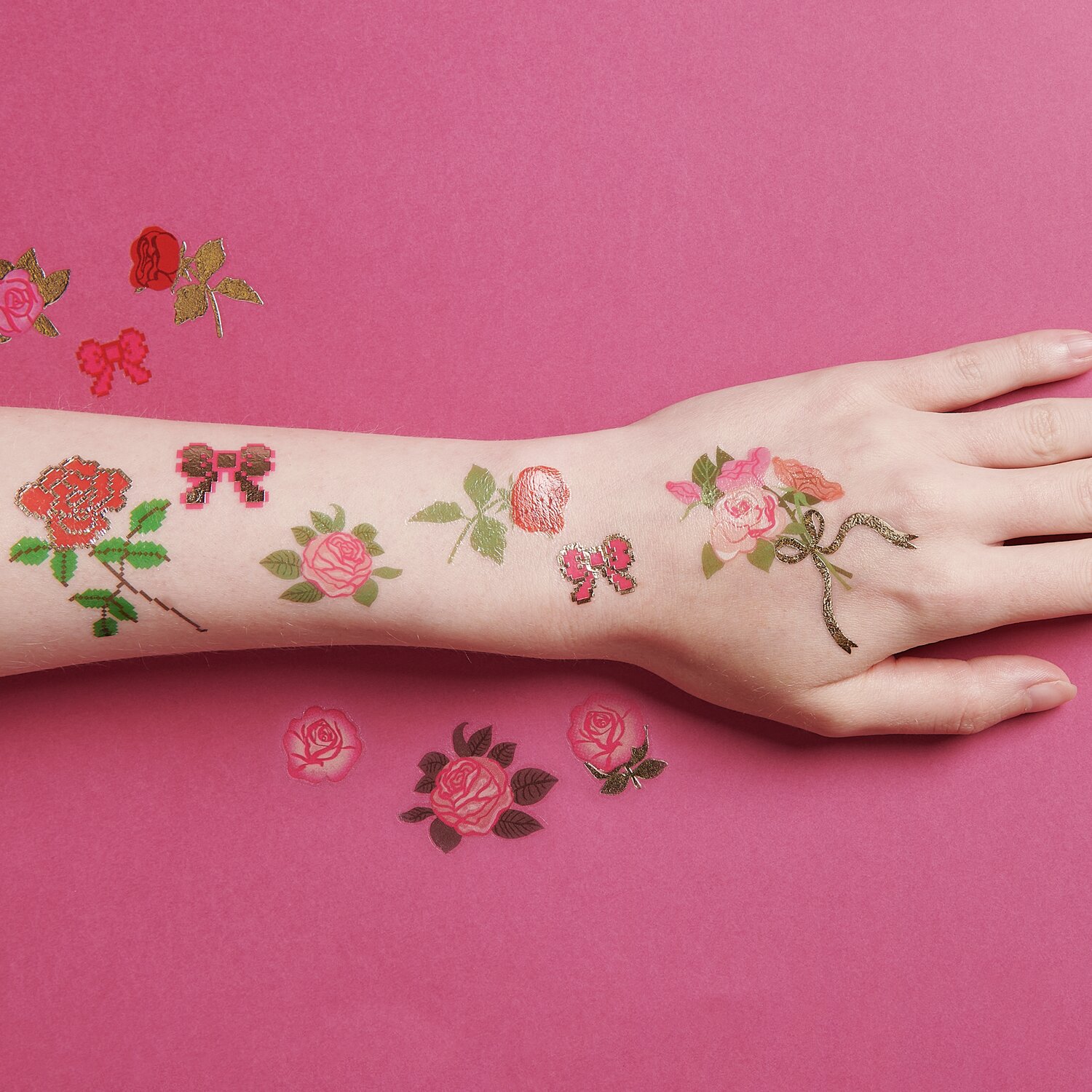 Tattoos Pixel Rosen: Temporäre Tattoos mit Rosen- und Schmetterlingsmotiven auf rosa Hintergrund.