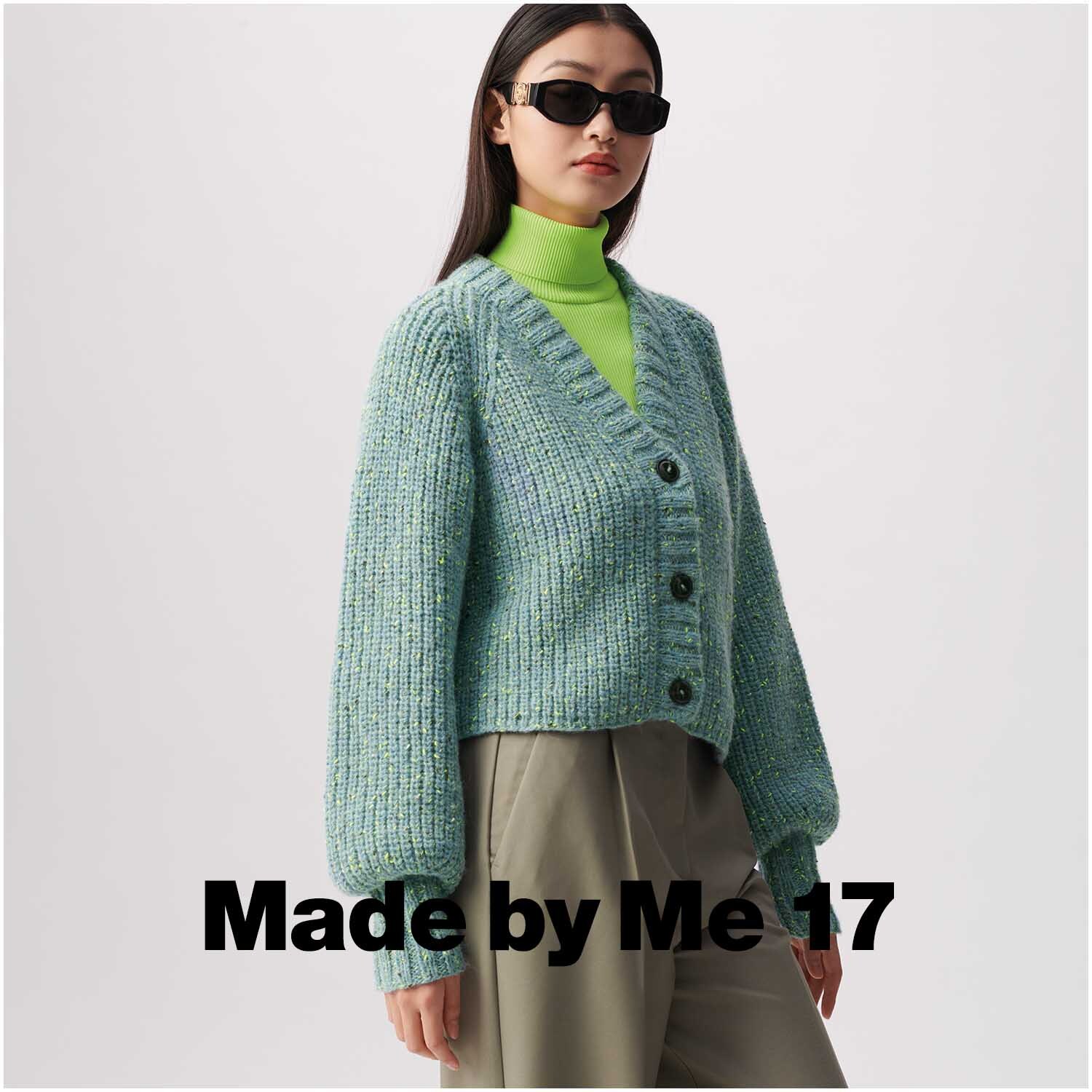 Rico Luxury Alpaca Superfine aran: Frau trägt hellblauen Strickcardigan mit Knöpfen, kombiniert mit neongrünem Rollkragenpullover.