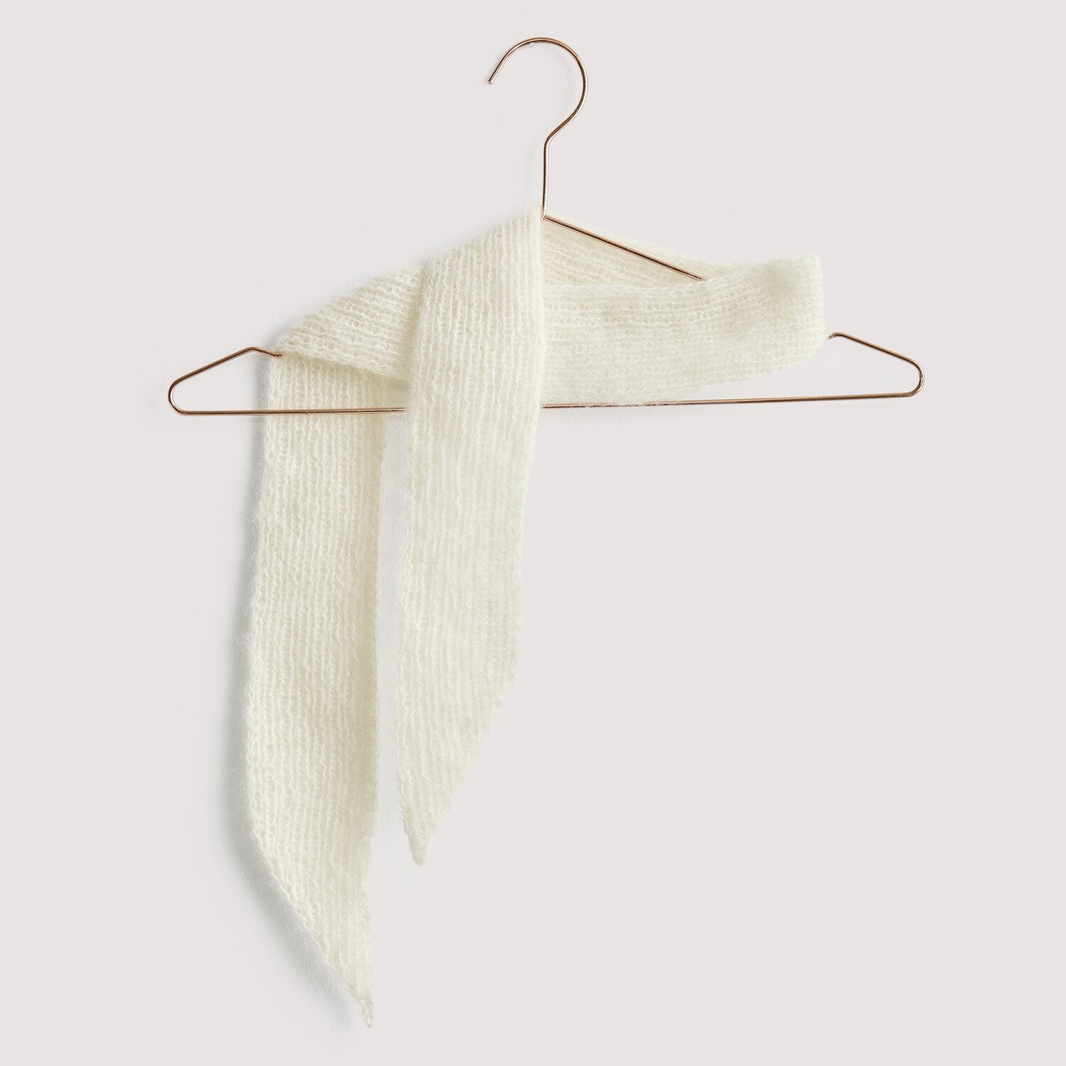 Luxury Knits - Premium Natural Fibres Sprachauswahl deutsch von Rico Design Strickset Tuch Modell 08 aus Luxury Knits: Weißes Tuch aus Premium Natural Fibres auf Kupferbügel.
