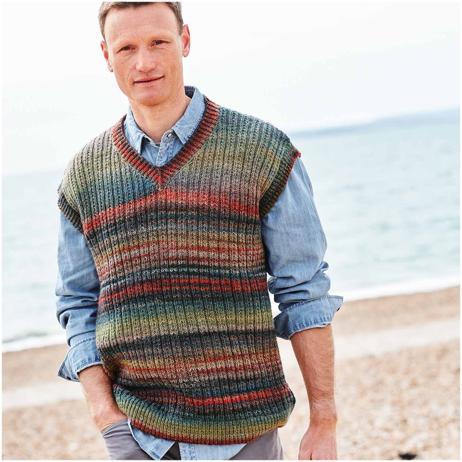 Strickset Pullunder Modell 18 aus Wonderball Special von Rico Design Creative Melange aran Wonderball Strickset Pullunder Modell 18, getragen von einem Mann am Strand.