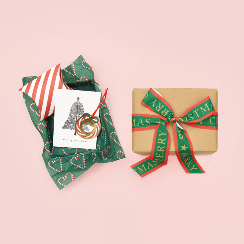 Weihnachtliche Geschenke arrangiert auf rosa Hintergrund.