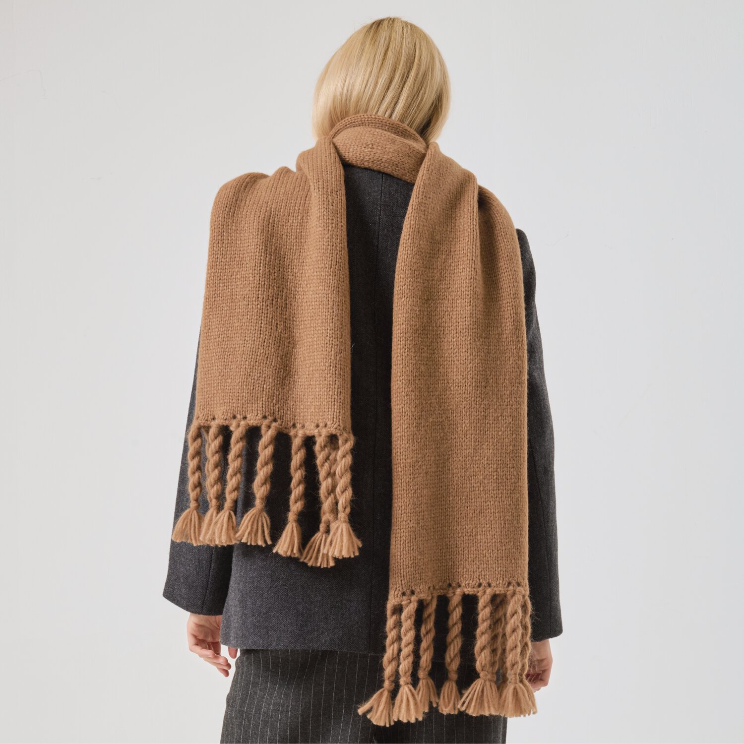 Strickset Schal Modell 14 aus Made by Me No. 21 von Rico Design Strickset Schal Modell 14: Frau trägt langen, braunen Schal mit Fransen, über dunklem Mantel.