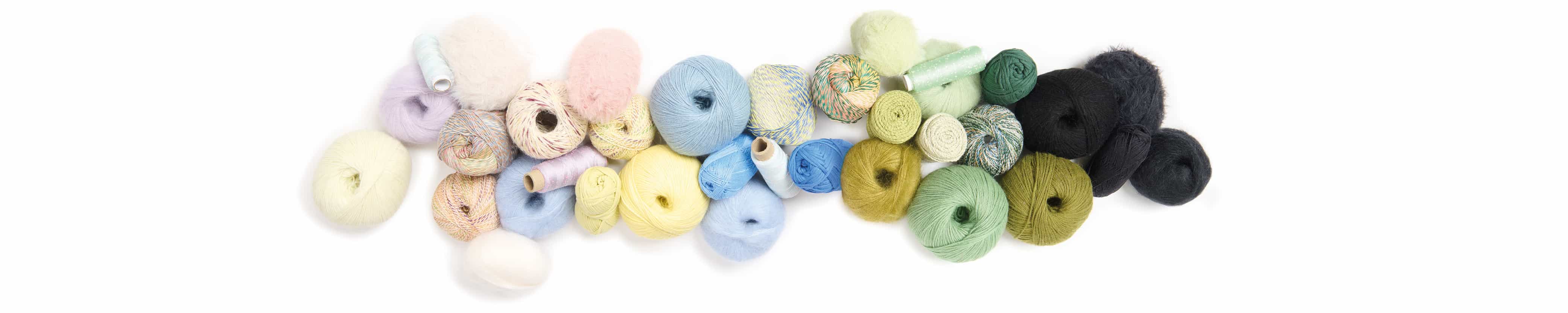 Wollknäuel in verschiedenen Farben aneinandergereiht 