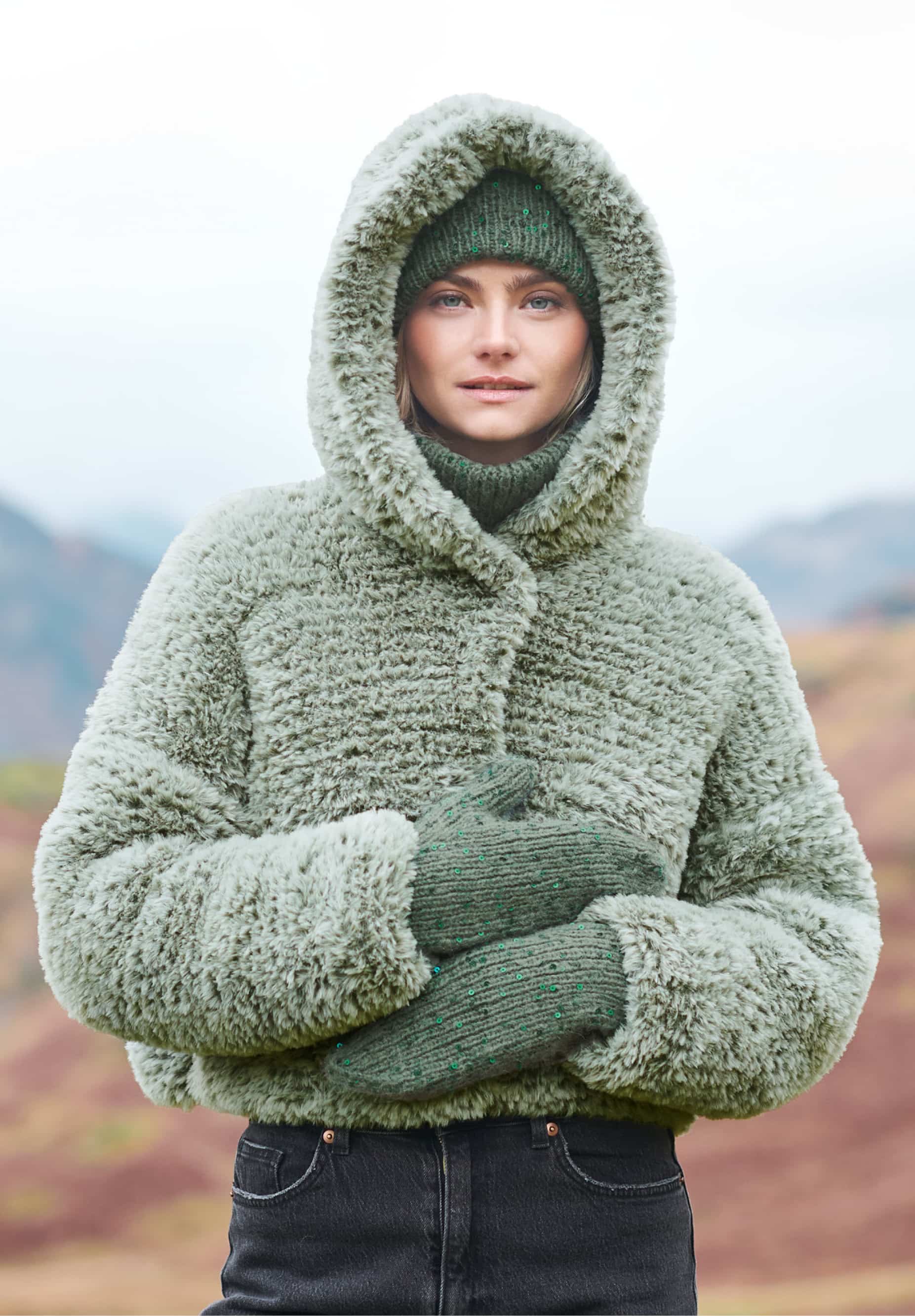 Frau trägt gestrickte, grüne Jacke in Felloptik: Modell 19 aus Lovewool No. 23
