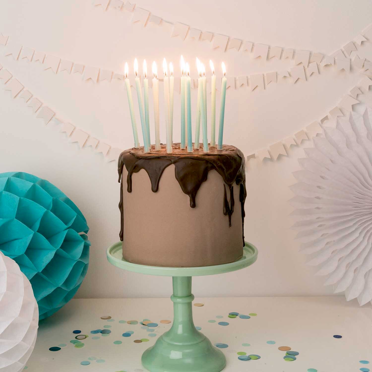 Kerzen lang 12cm, Rico Design, auf festlicher Geburtstagstorte mit Schokoguss, pastellfarbenen Partydekoelementen und Konfettistreuung im Hintergrund