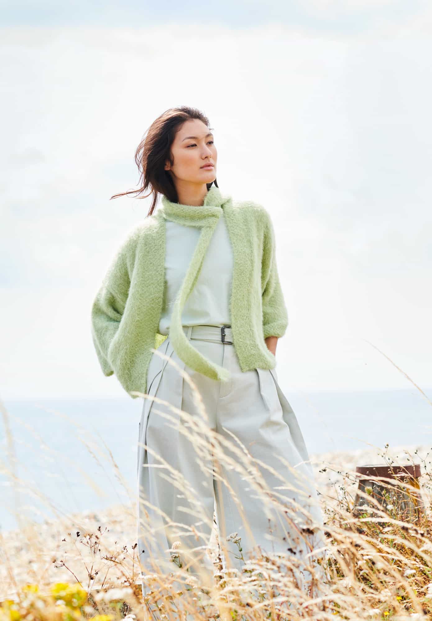 Frau trägt gestrickte Jacke mit Schal in Grün: Modell 20 aus Lovewool No. 22