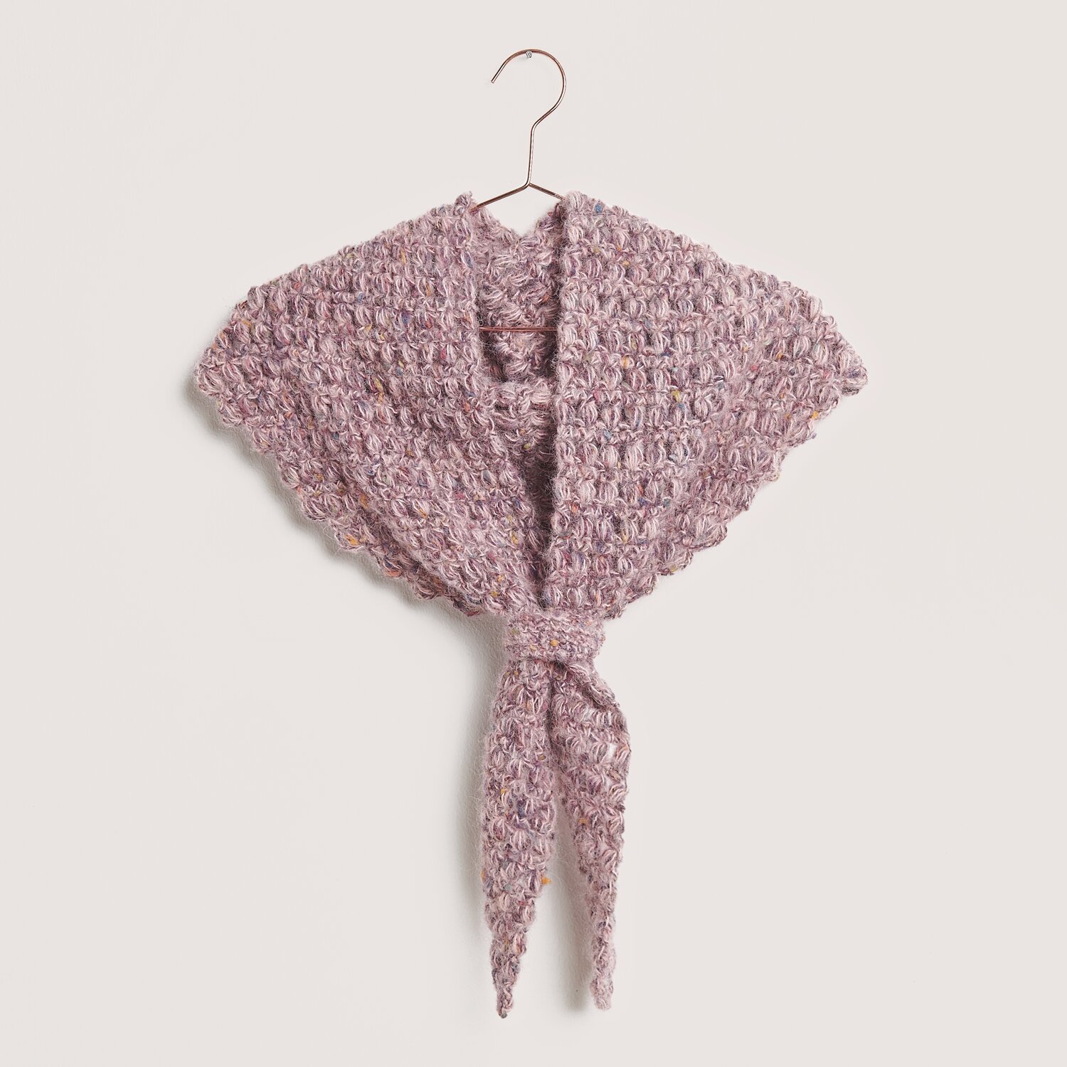 Made by Me No. 21 Herbst-Winter Sprachauswahl deutsch von Rico Design Made by Me No. 21 Herbst-Winter Schal in Lila, gestrickt aus Fashion Cotton Alpaca Fun Neps, hängt an einem Kleiderbügel.