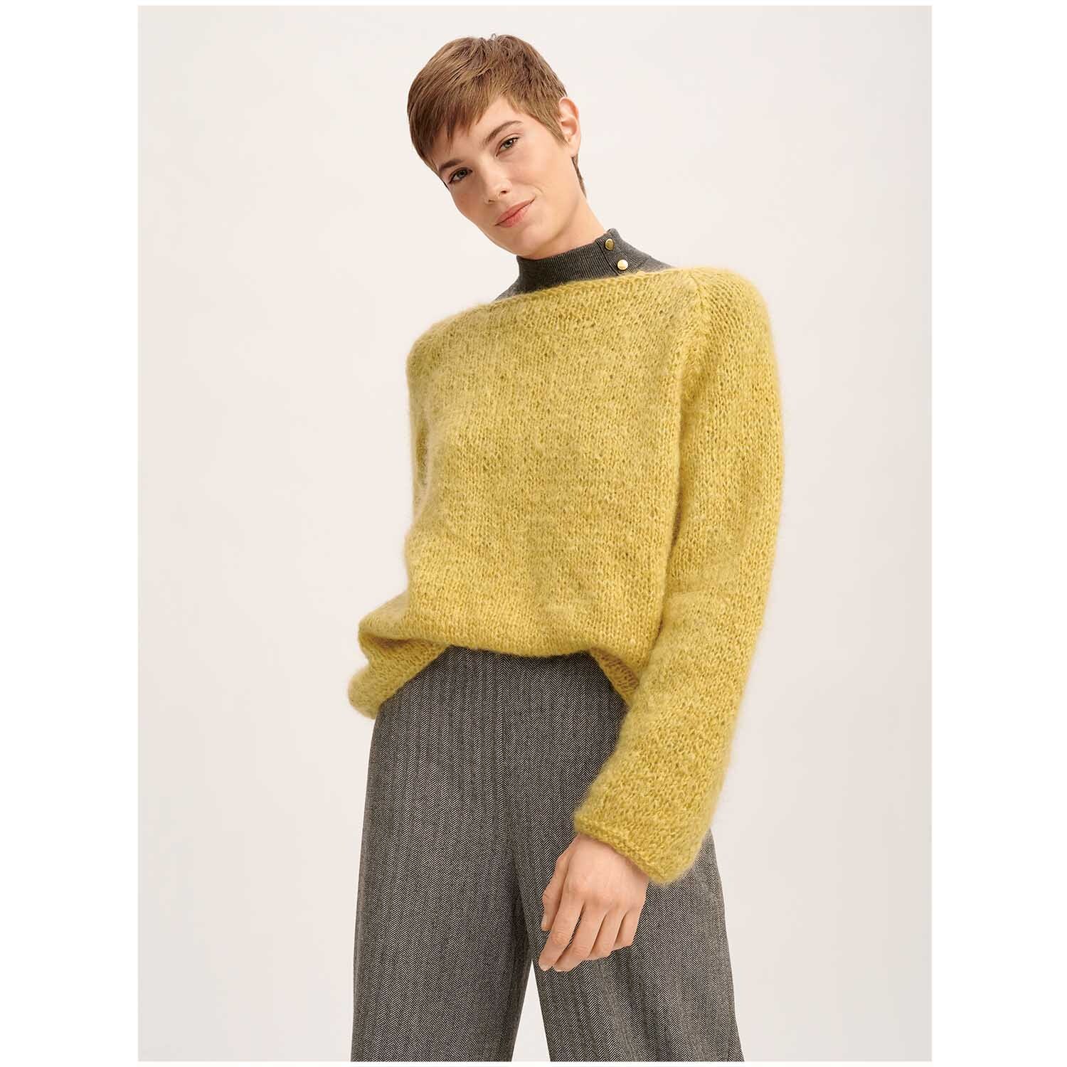 Fashion Mohair Merino Chunky 50g 100m Farbe Senf von Rico Design Fashion Mohair Merino Chunky: Person trägt einen senffarbenen Pullover von Rico Design, kombiniert mit grauer Hose.